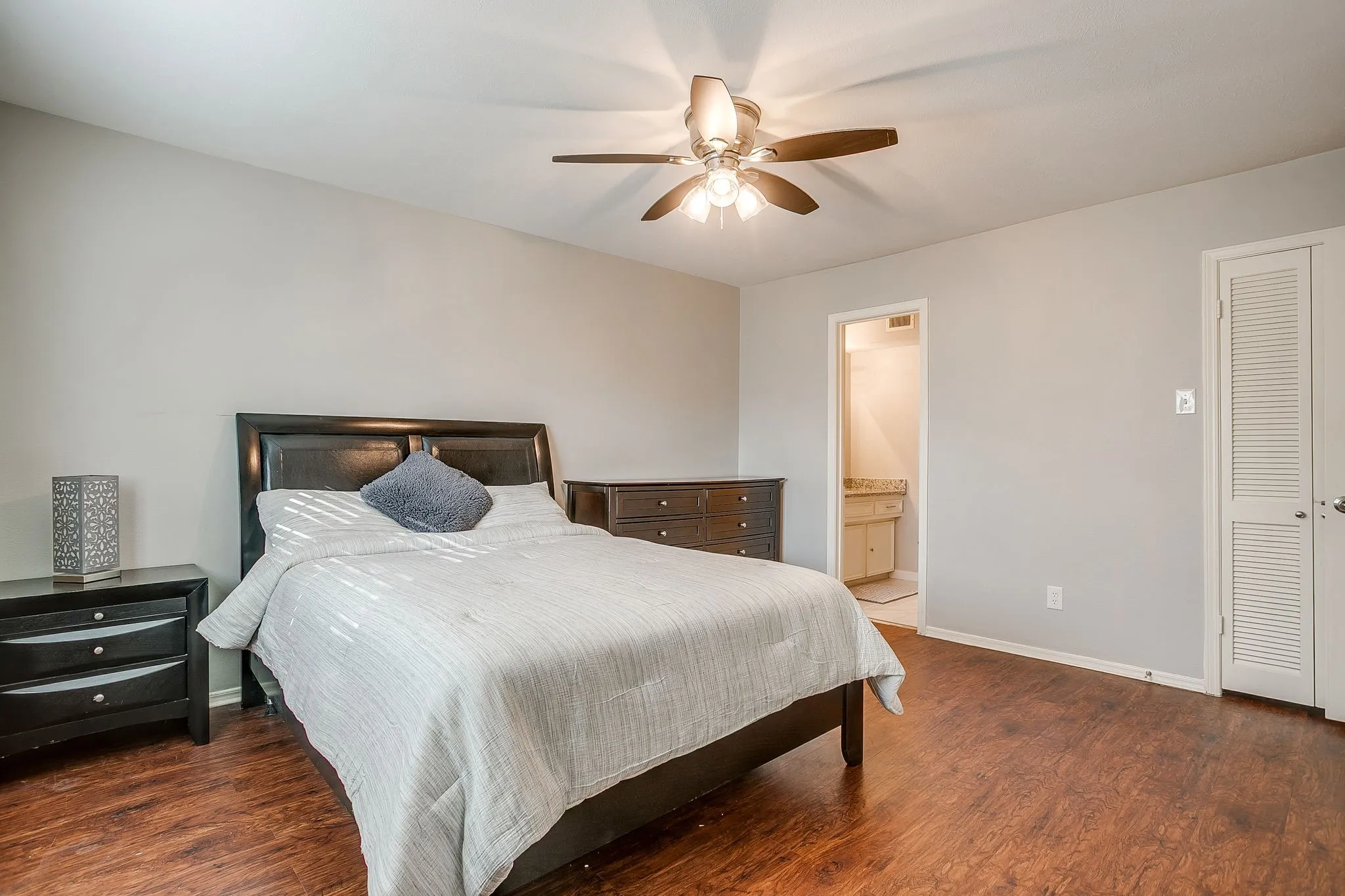 Bedroom featuring rich wood-finish flooring and light gray walls