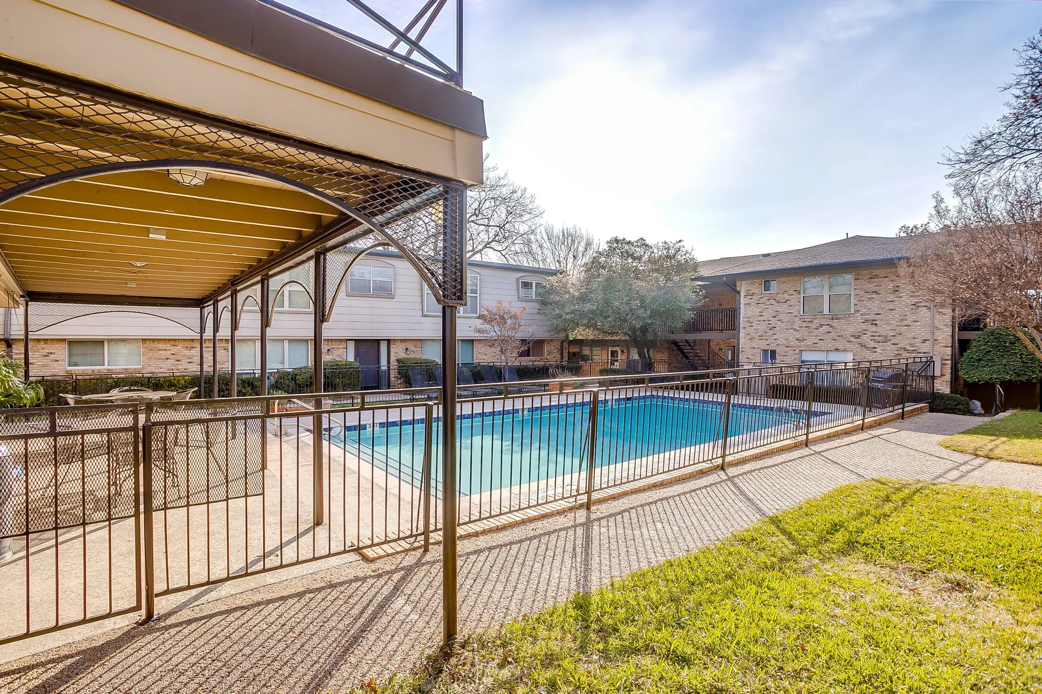 Outdoor swimming pool with surrounding black metal fencing