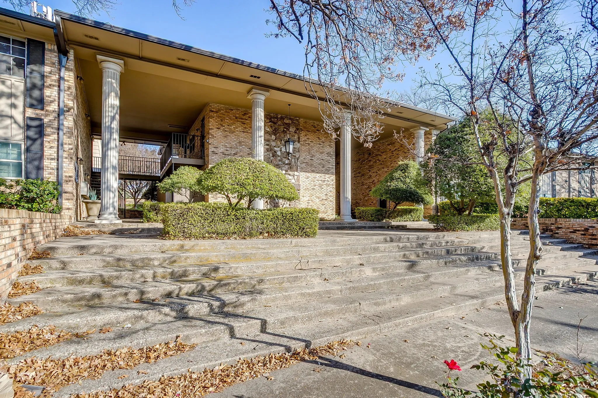 Columned portico entrance featuring a brick and stone facade