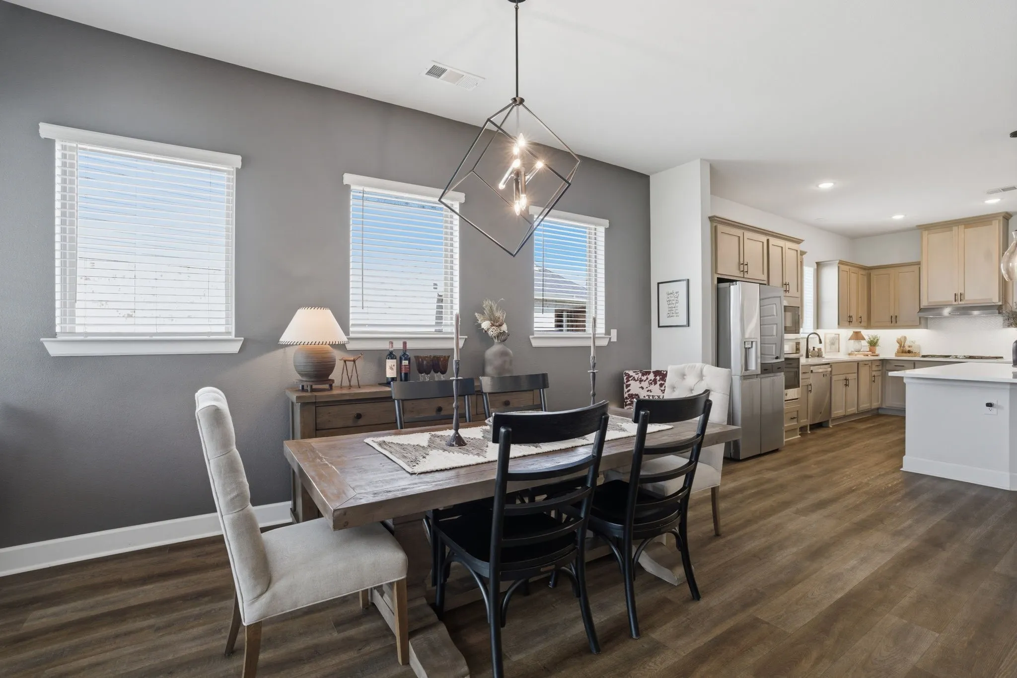 This image showcases a different perspective of the spacious, open-concept dining area, with a particular focus on the striking contemporary geometric chandelier that serves as a focal point.