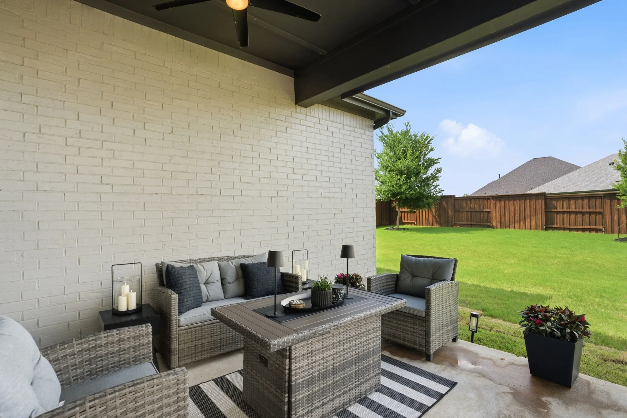 This photo showcases a generously sized covered patio, providing a comfortable outdoor living space, complemented by a sturdy board on board wooden privacy fence, ensuring a serene and secluded environment.