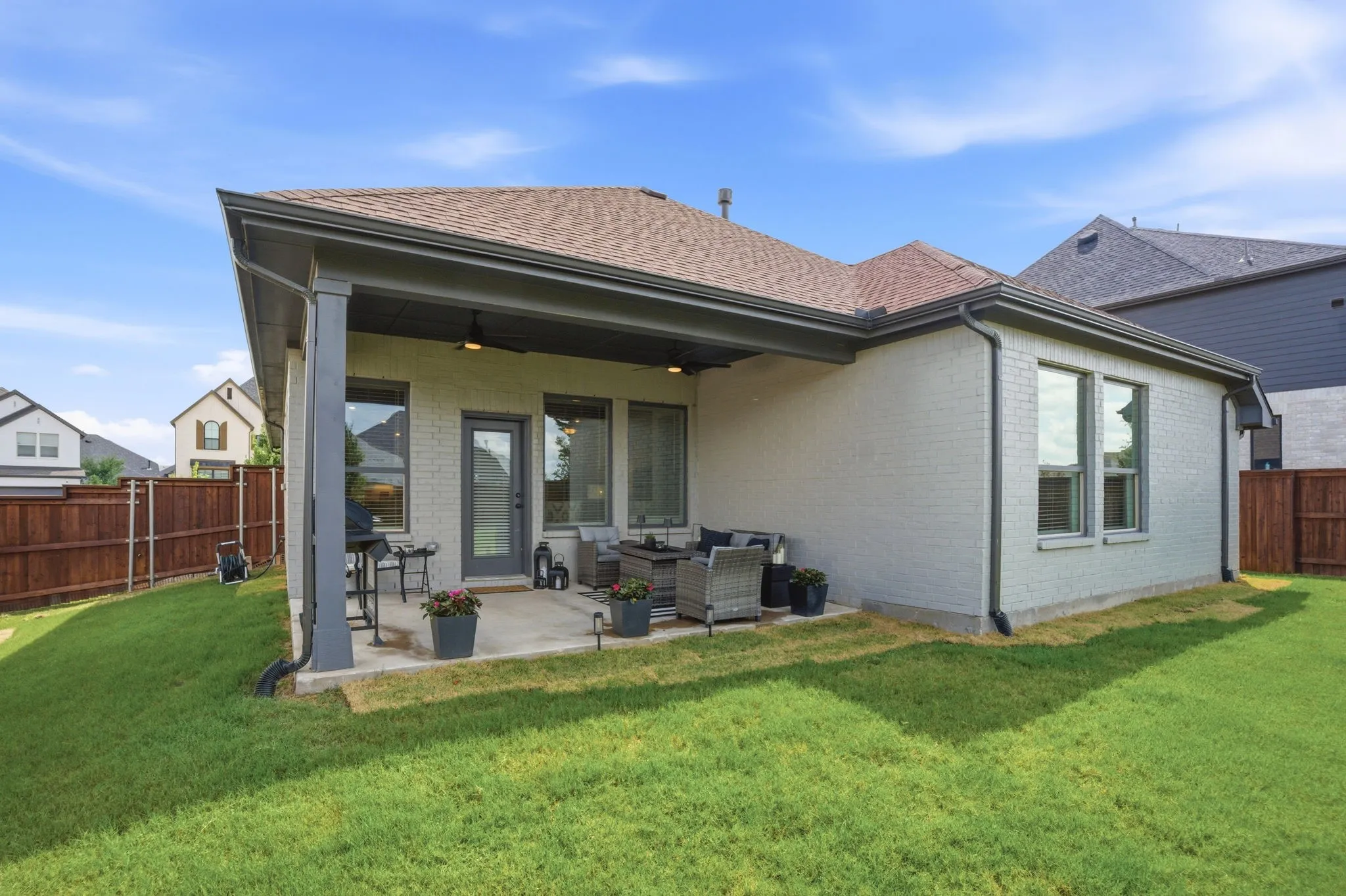 Expansive backyard featuring a covered patio, concrete slab, and a privacy fence
