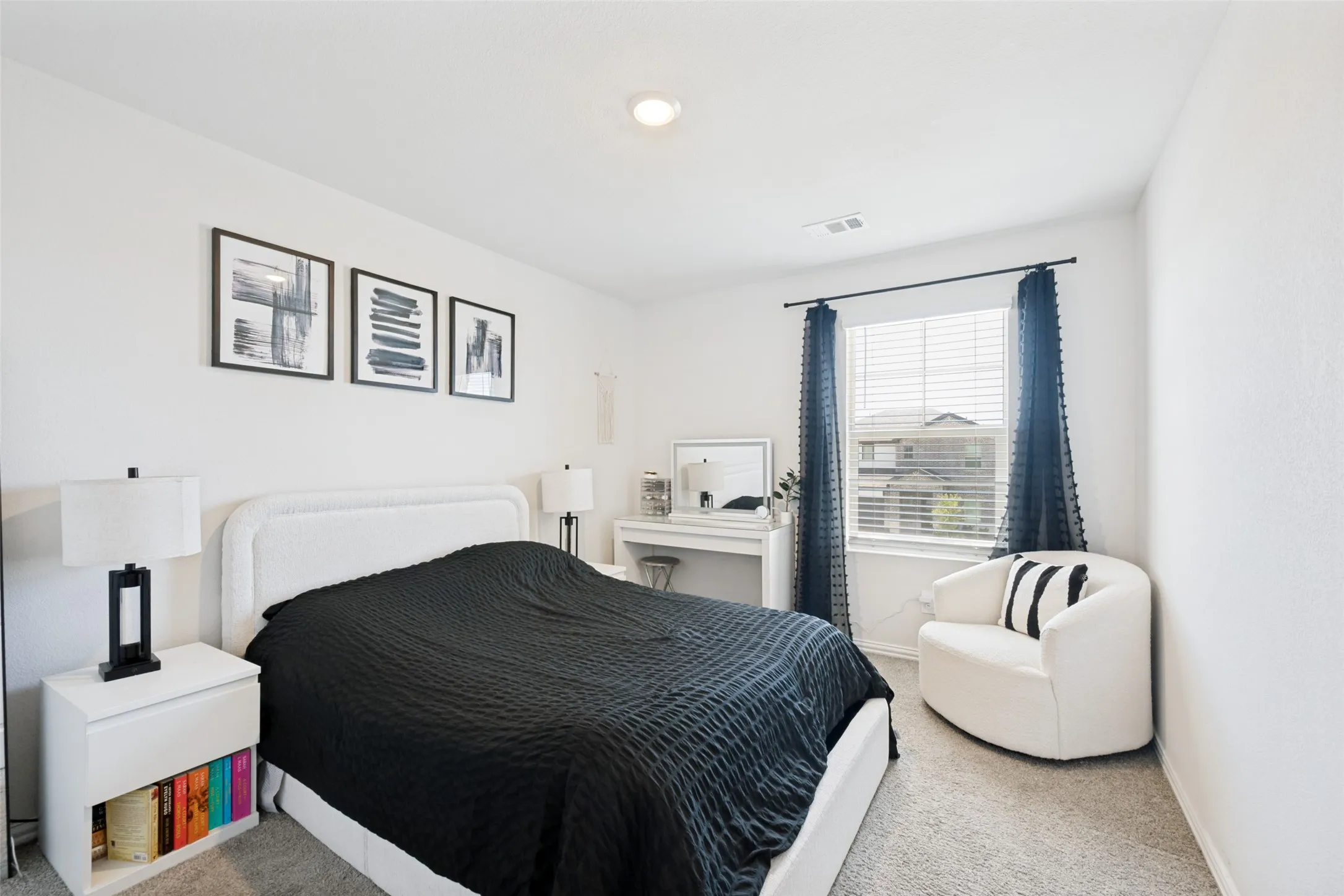 Carpeted bedroom featuring white walls, a recessed ceiling light, and a window with blinds and dark curtains