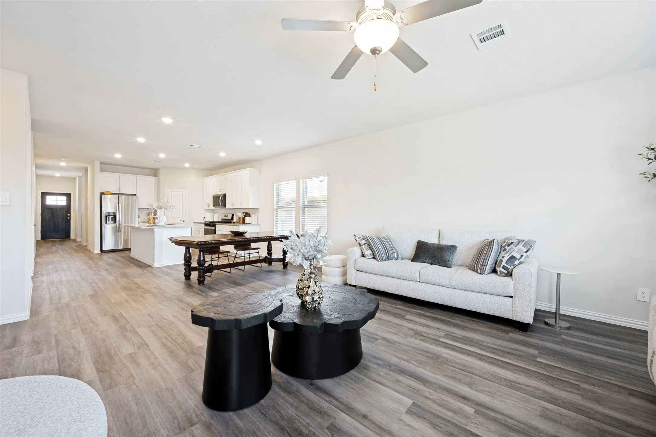Open-concept living area featuring wood-finish flooring, recessed lighting, and a ceiling fan