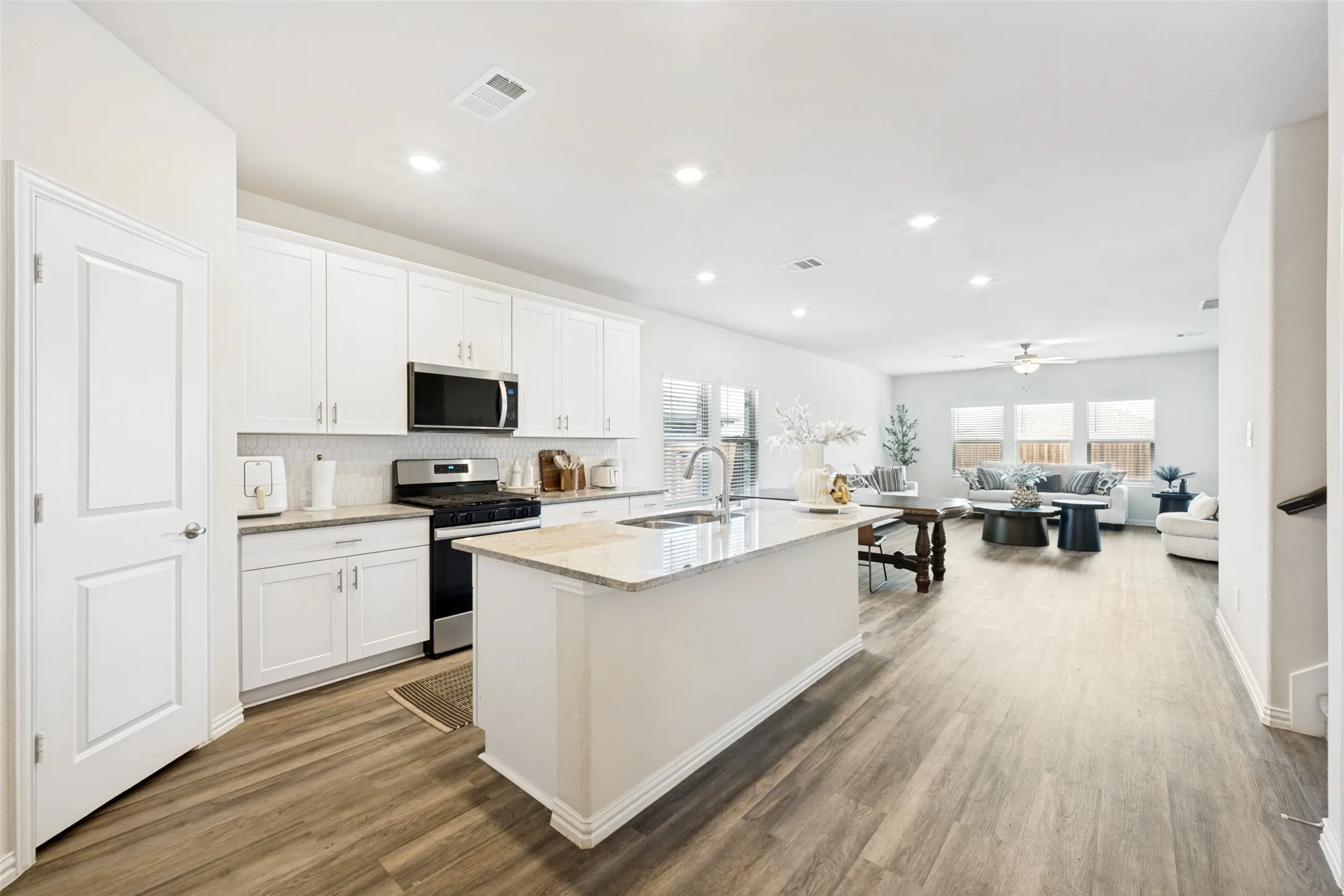 Open-concept living space with wood-finish flooring extending throughout