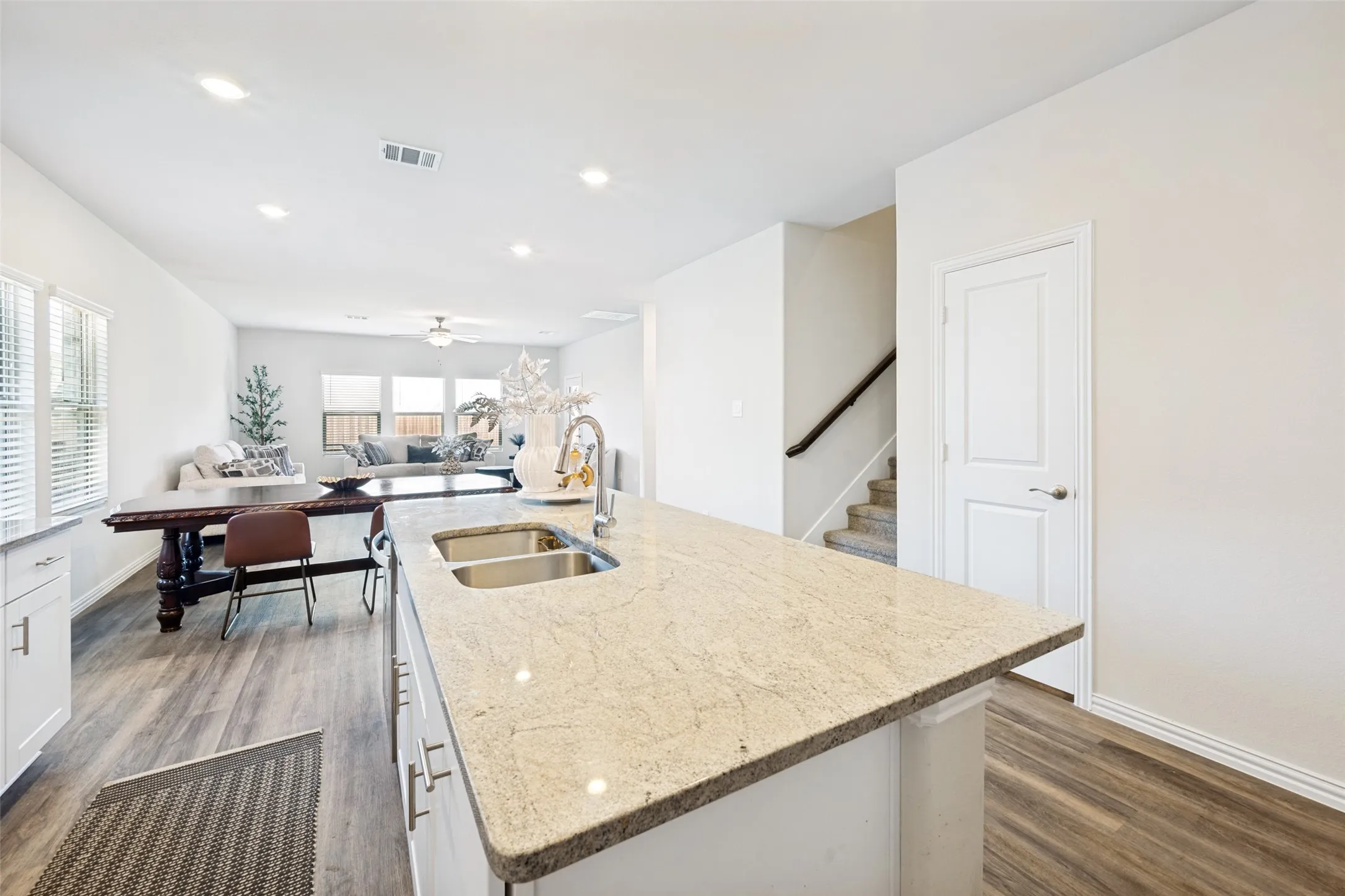 Kitchen island featuring a double basin stainless steel sink and light-toned countertop