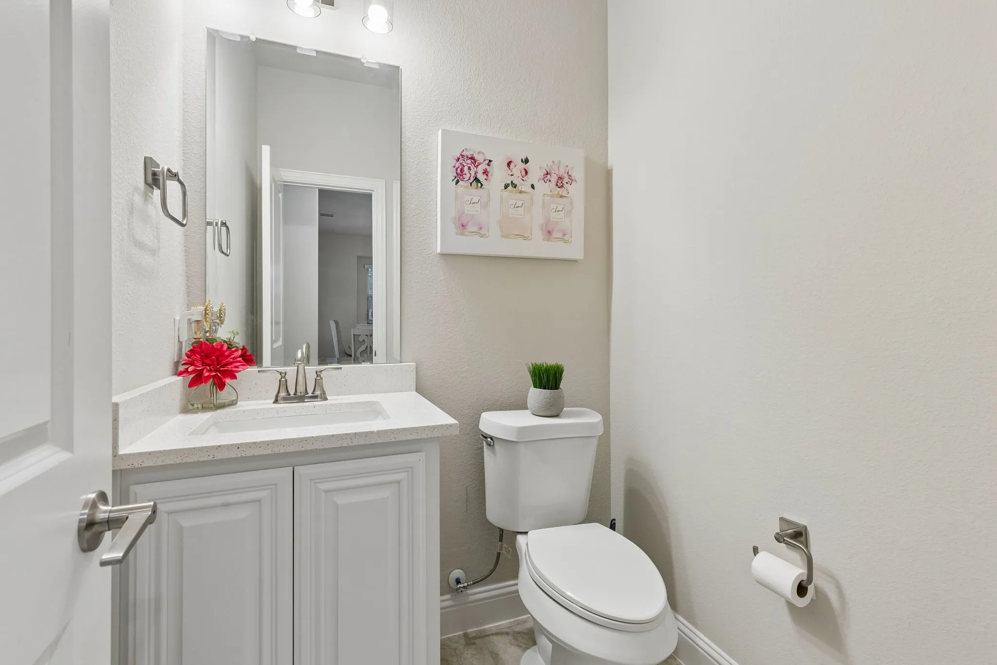 Powder Bathroom featuring a white vanity with built-in sink, quartz-finish countertop, and brushed nickel faucet