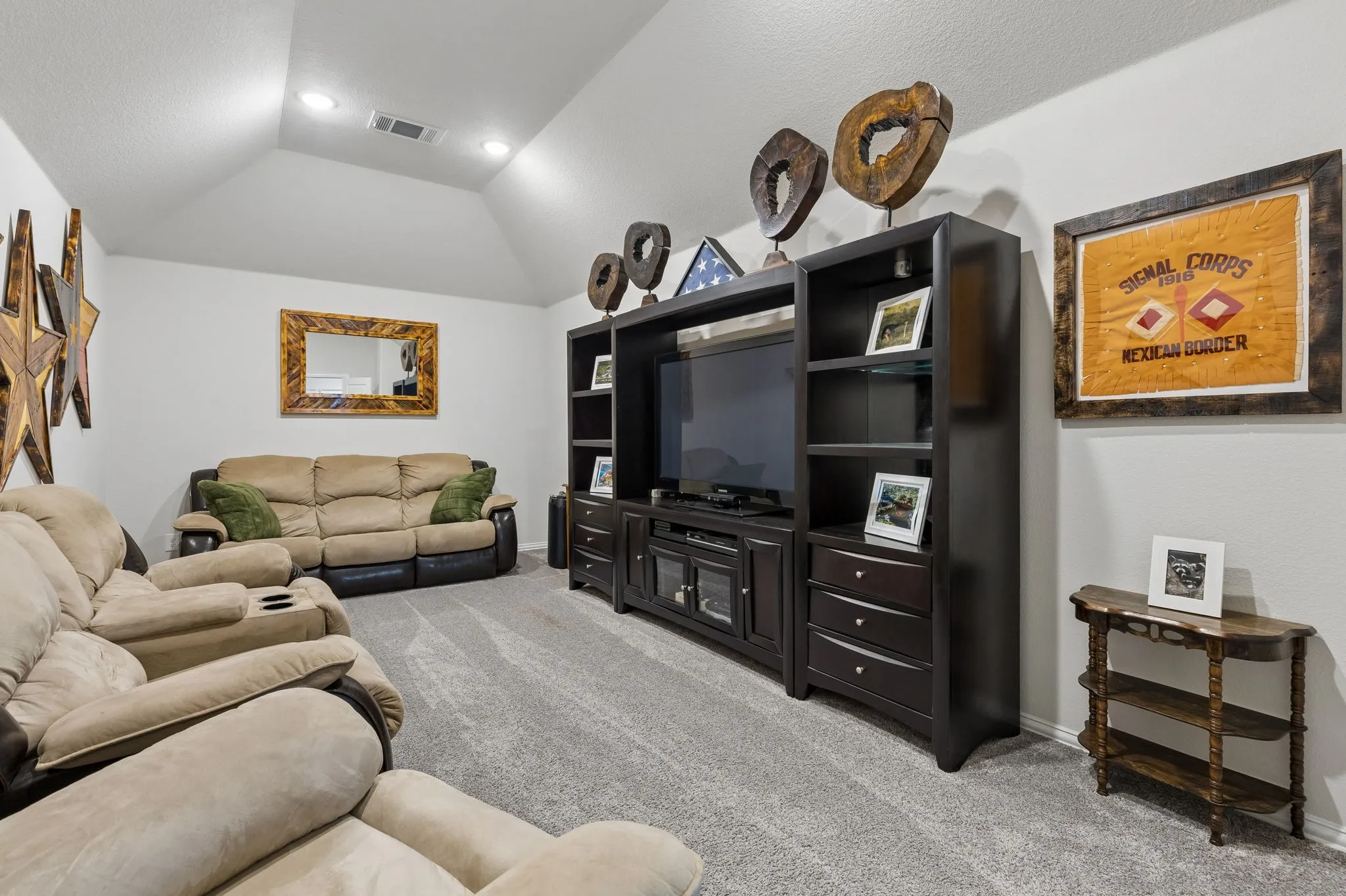 Spacious Media room featuring vaulted ceilings with recessed lighting, light gray carpeting, and a built-in media center with shelving and storage drawers