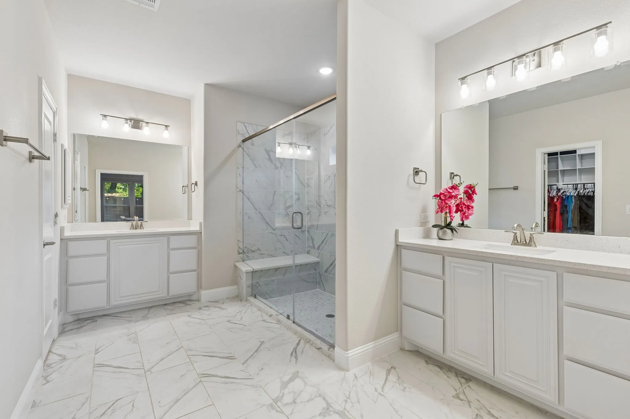 Primary Ensuite Spacious bathroom featuring dual vanity cabinets with undermount sinks, stone-finish countertops, and chrome fixtures