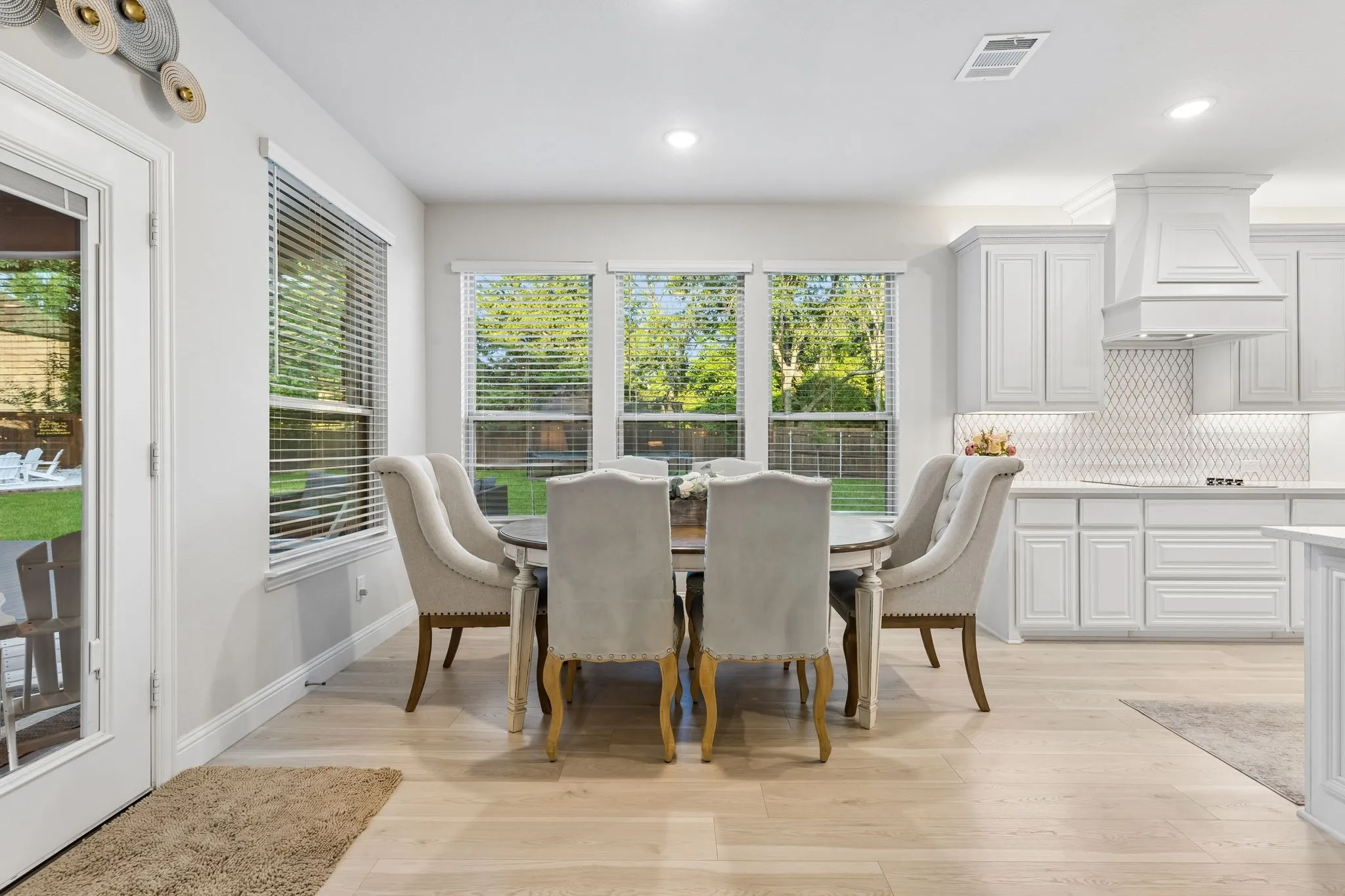 Dining area featuring wood-finish flooring, recessed lighting, and a set of three windows