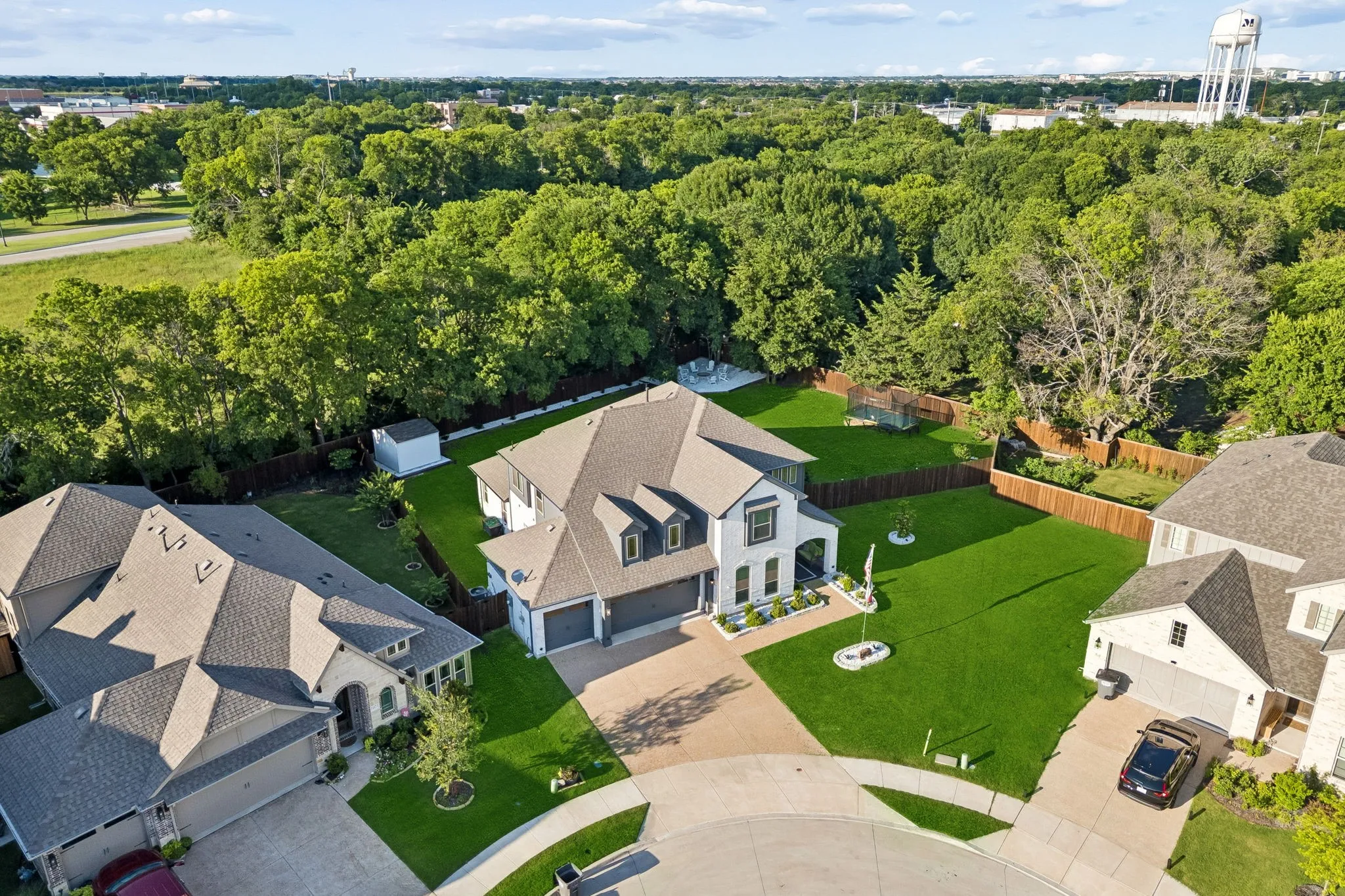 Contemporary two-story residence on Oversized lot, featuring a light-colored brick and siding exterior, a multi-gabled roof, and an attached three-car garage