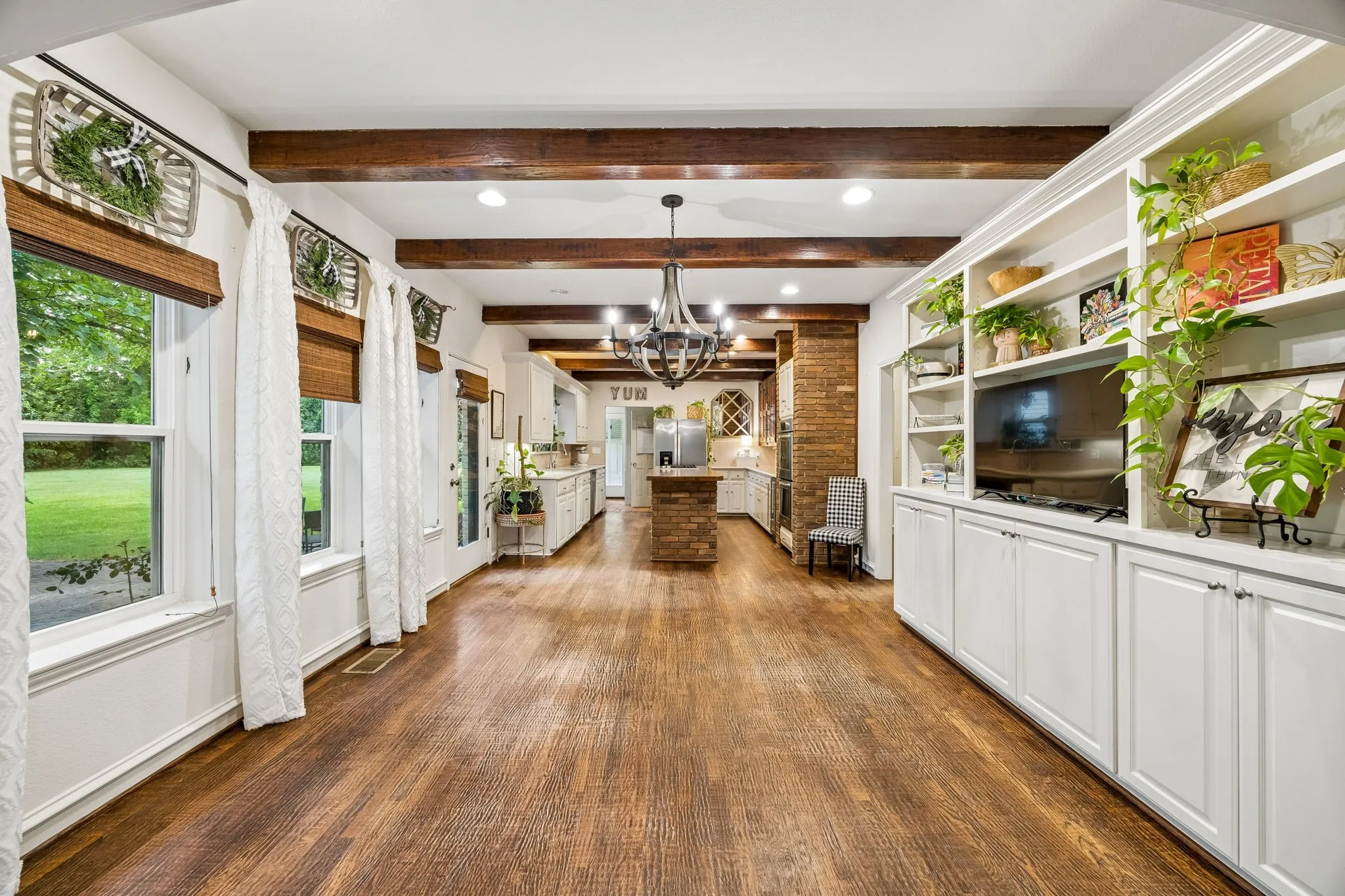 View from living room to the dining area and kitchen.  Beamed ceilings, built-ins and great views of the back yard.