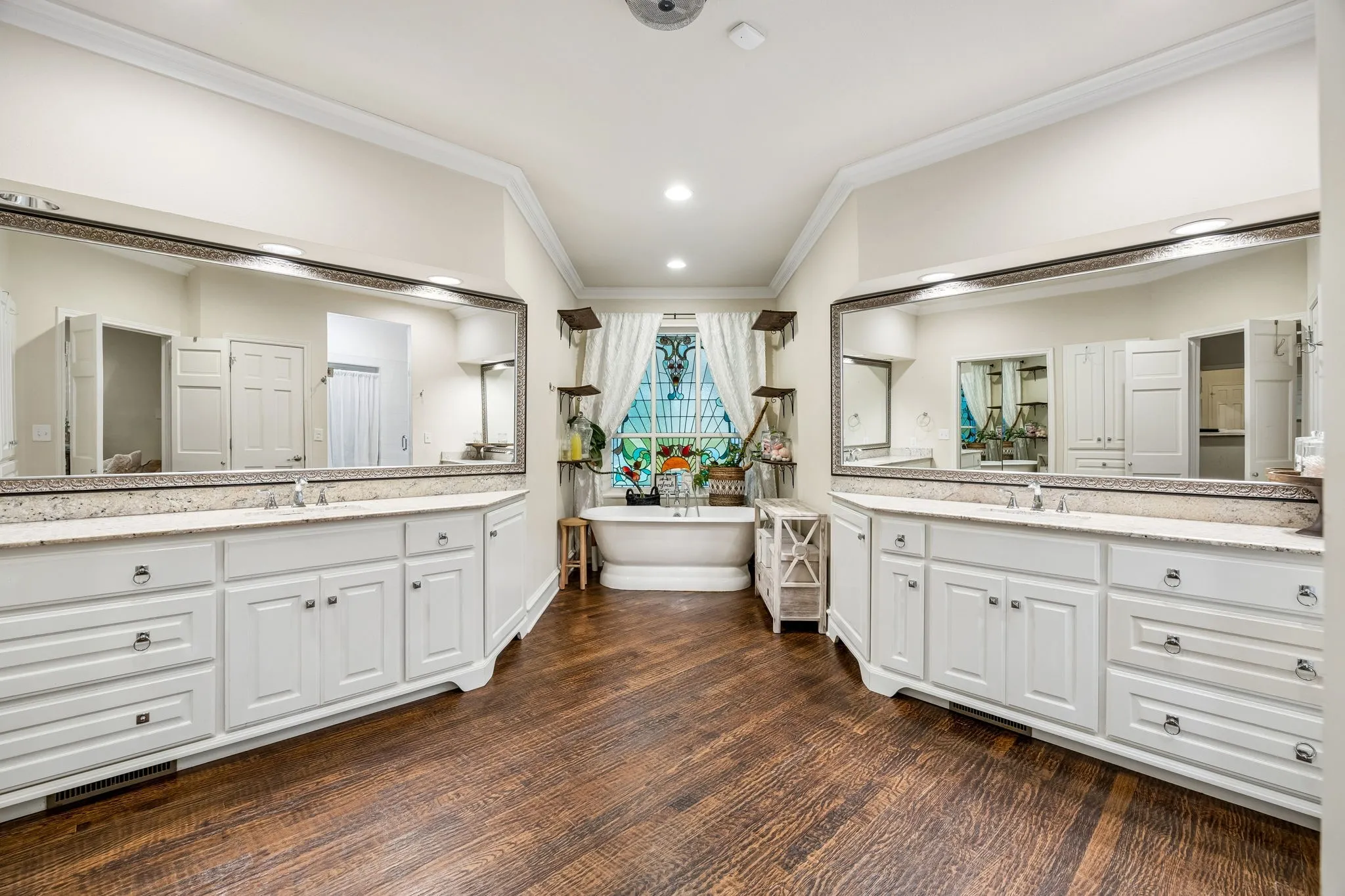 The oversized ensuite primary bath features separate extended vanities and a garden tub.