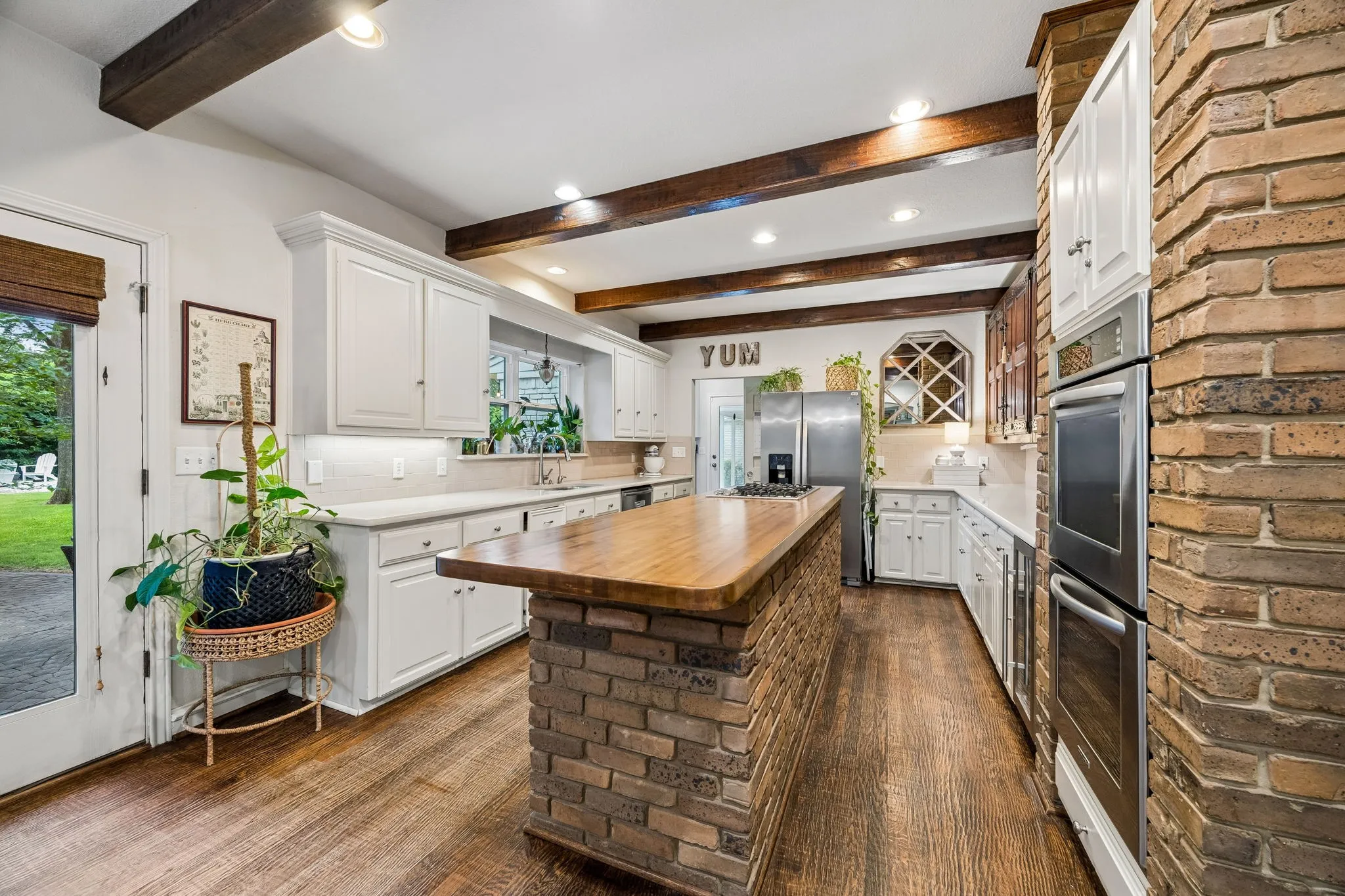 The kitchen boasts abundant storage space, a butcher block topped island, and double ovens.