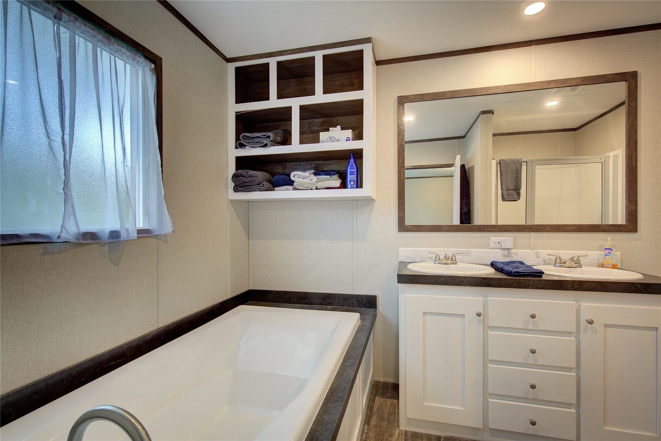 Primary bathroom has soaking tub, separate shower, double vanity, linen shelves.