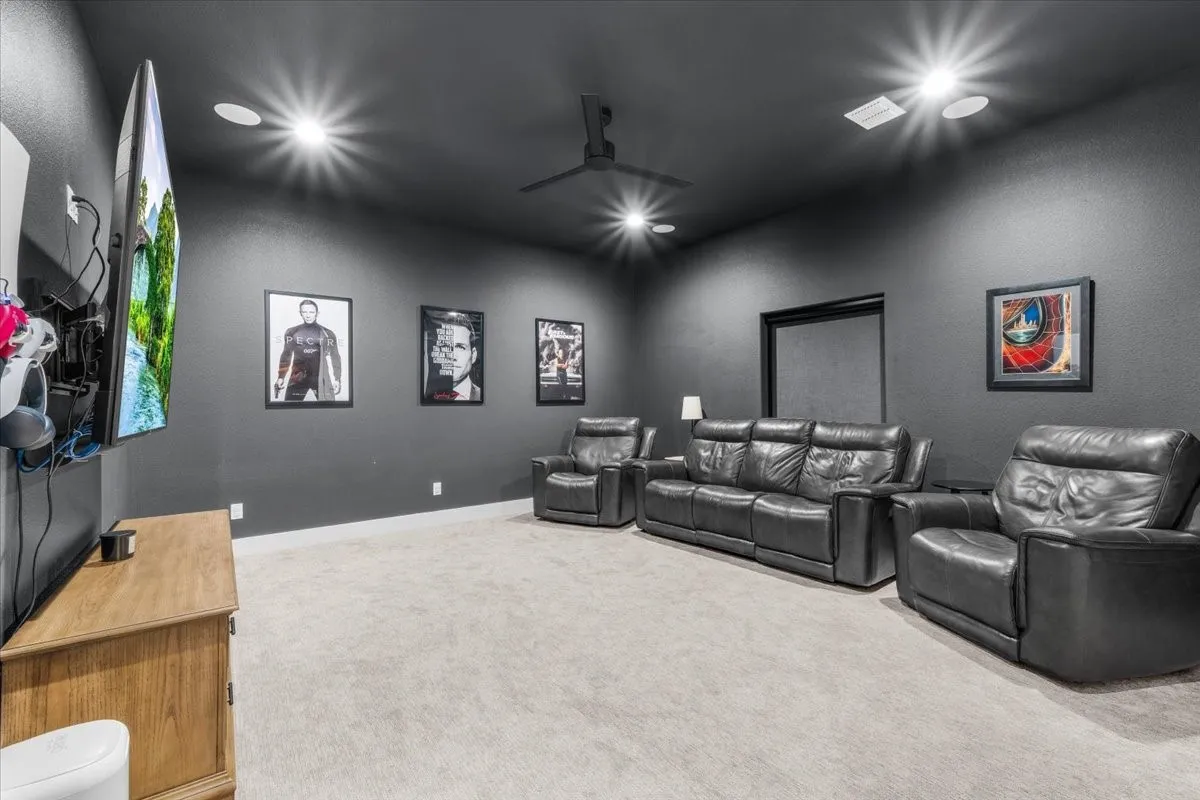 Media room is carpeted room dark gray walls and ceiling, featuring recessed lighting, a ceiling fan, blackout roller shade and closet.