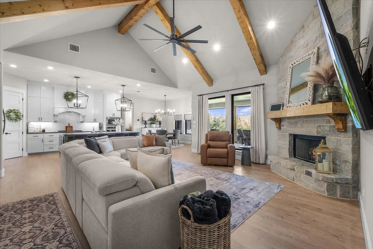Living room featuring stone fireplace and wood mantel.