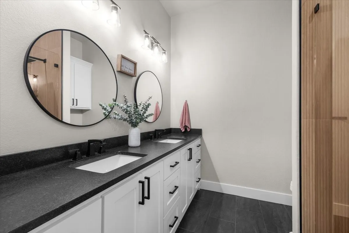 Full bathroom featuring a dual vanity with granite countertops.