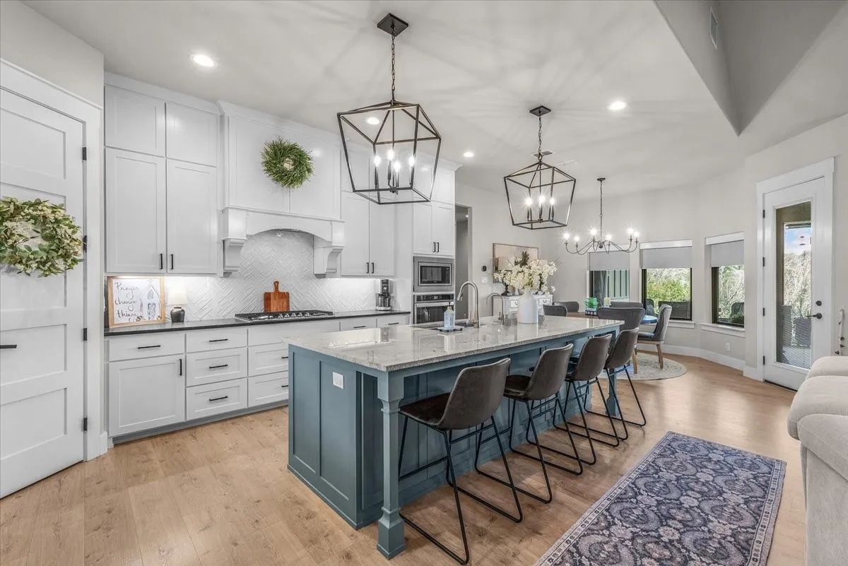 Kitchen featuring a large central island with storage underneath and decorative pendant lighting.