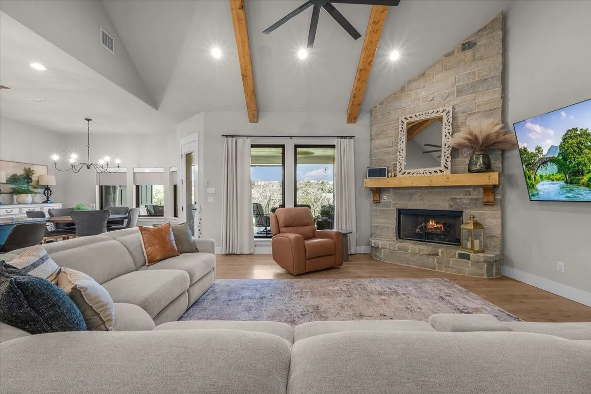 Living room with natural lighting from large windows outlooking the back of property.