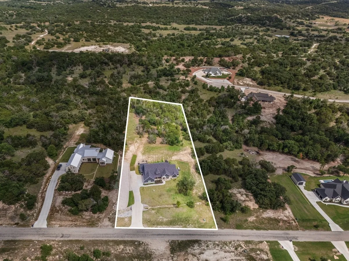 Aerial view of the 2 acres outlined featuring a green belt at back of property