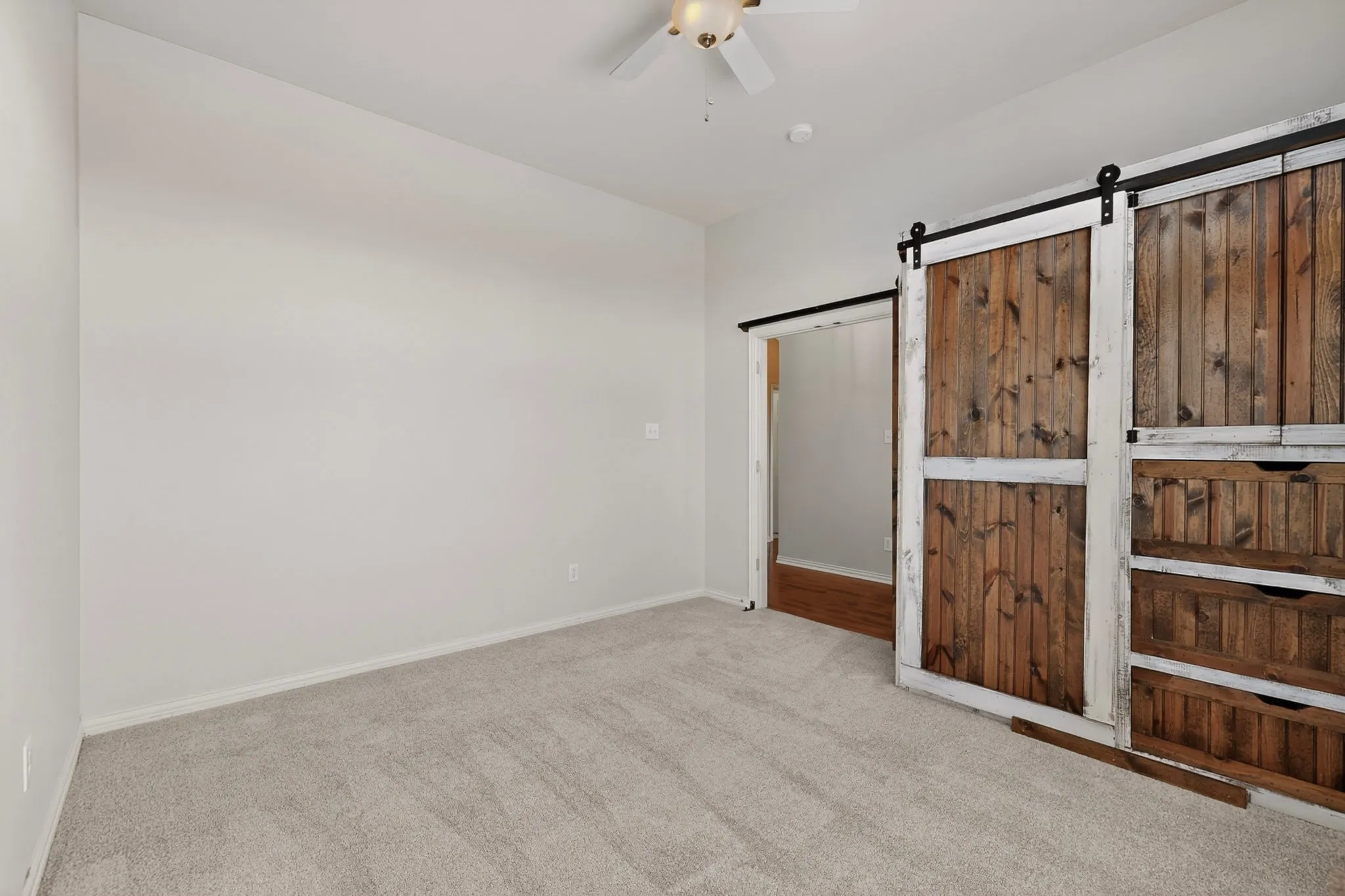 Neutral-toned carpeted flooring with light-colored walls and white trim