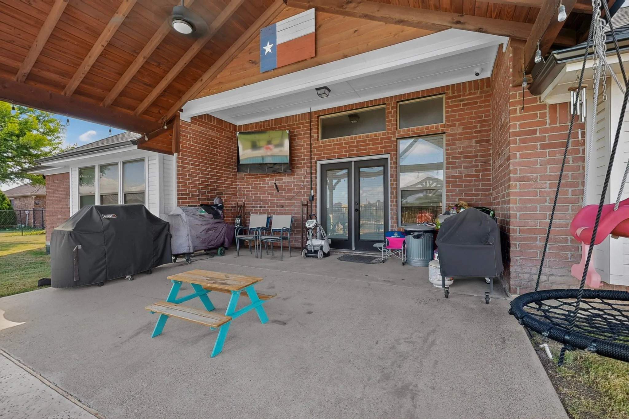 Expansive covered patio featuring a wood-finish ceiling with exposed beams, ceiling fan, and recessed lighting