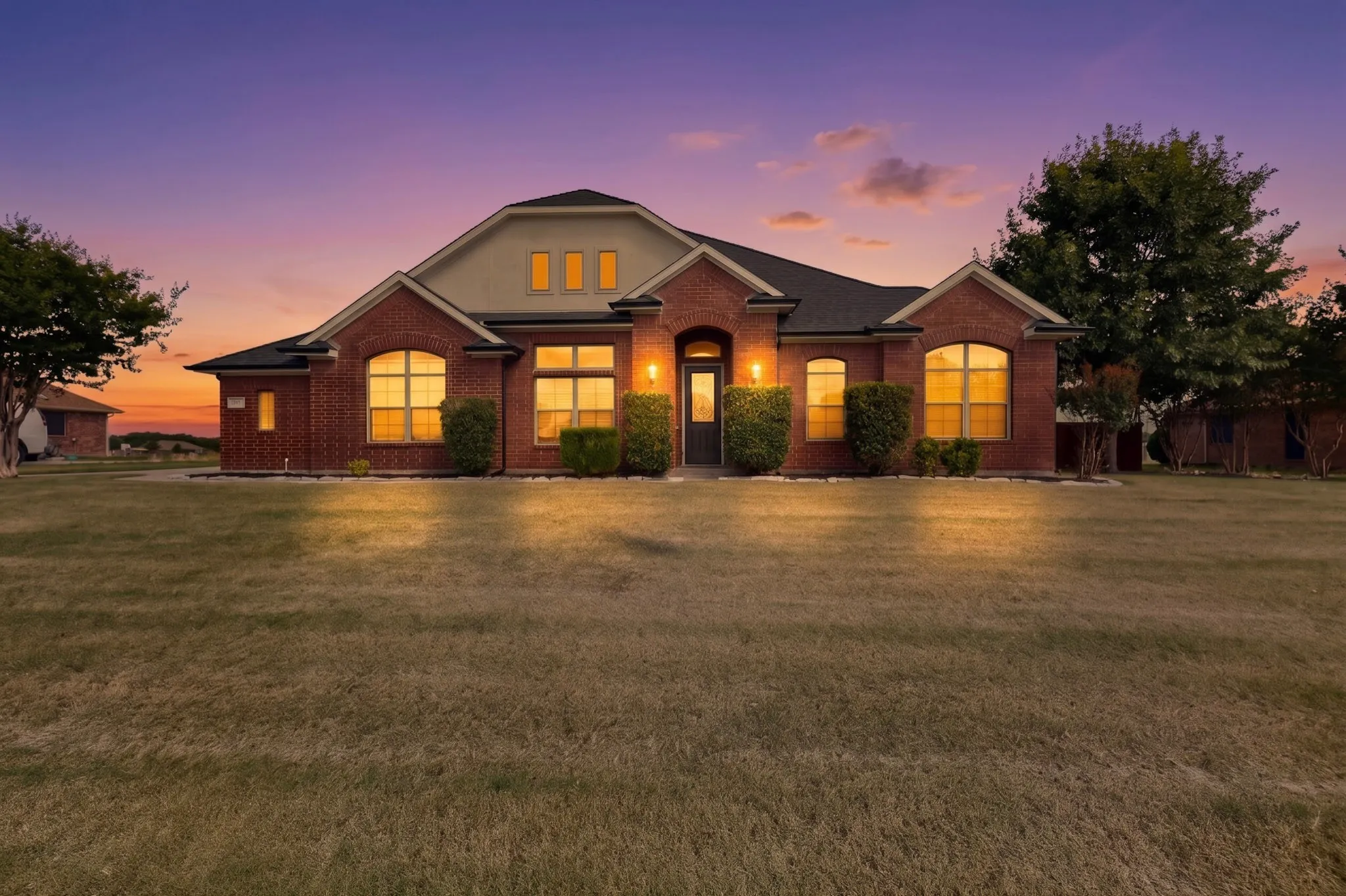 Brick exterior residence with a dark roof and light-colored siding accents