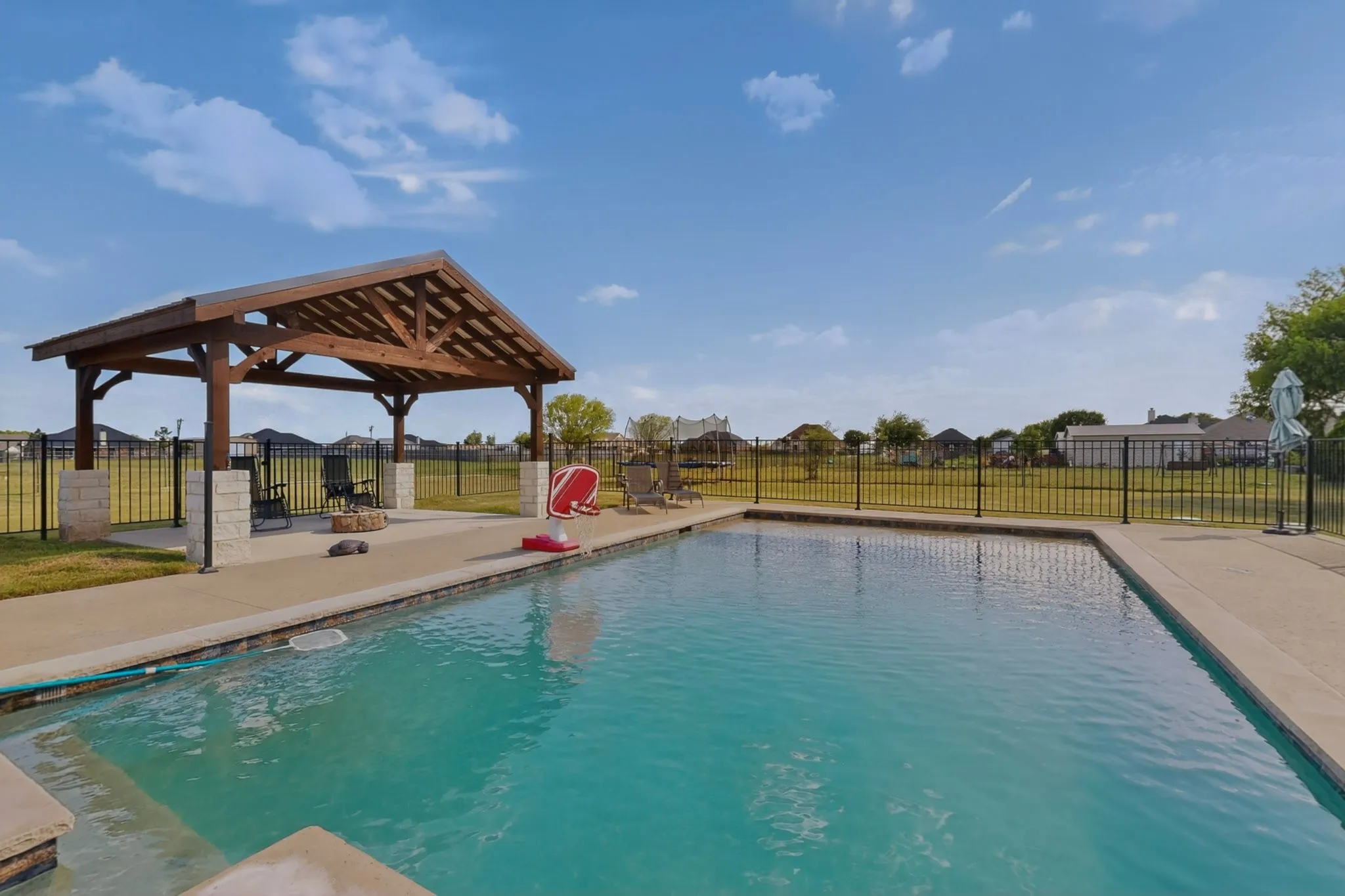 In-ground rectangular swimming pool with concrete decking