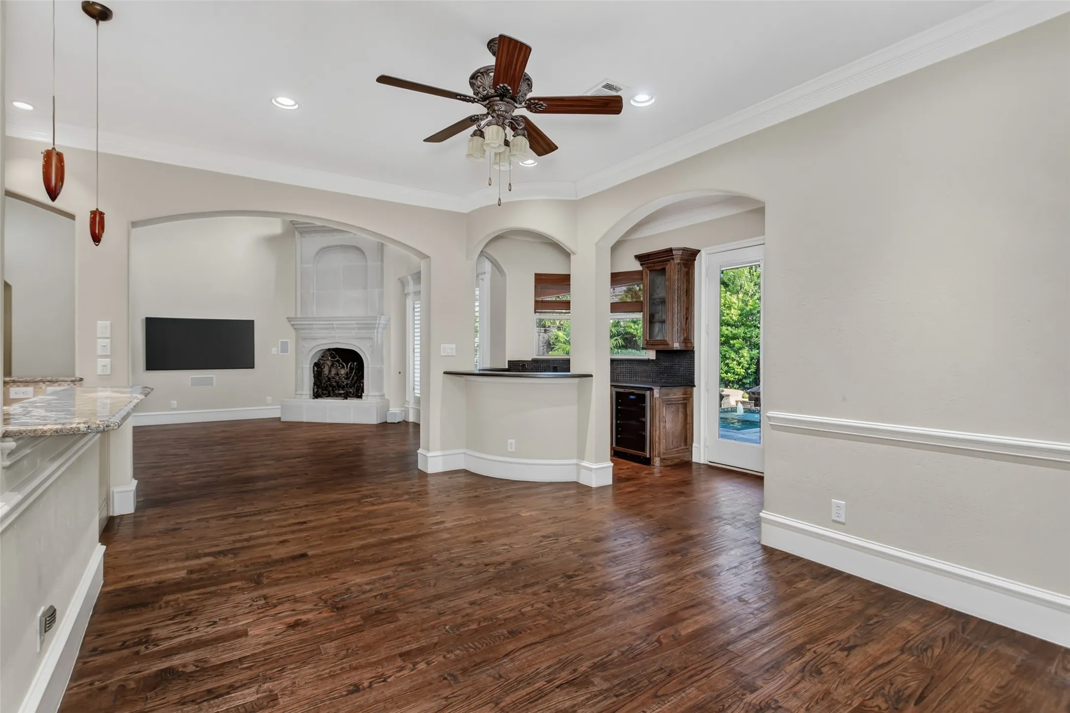 The open-concept breakfast room flows effortlessly into the family room with corner wetbar with built in cabinetry, ice maker and beverage refrigerator. French doors open to the outdoor living area, creating an ideal space for gathering and entertaining.