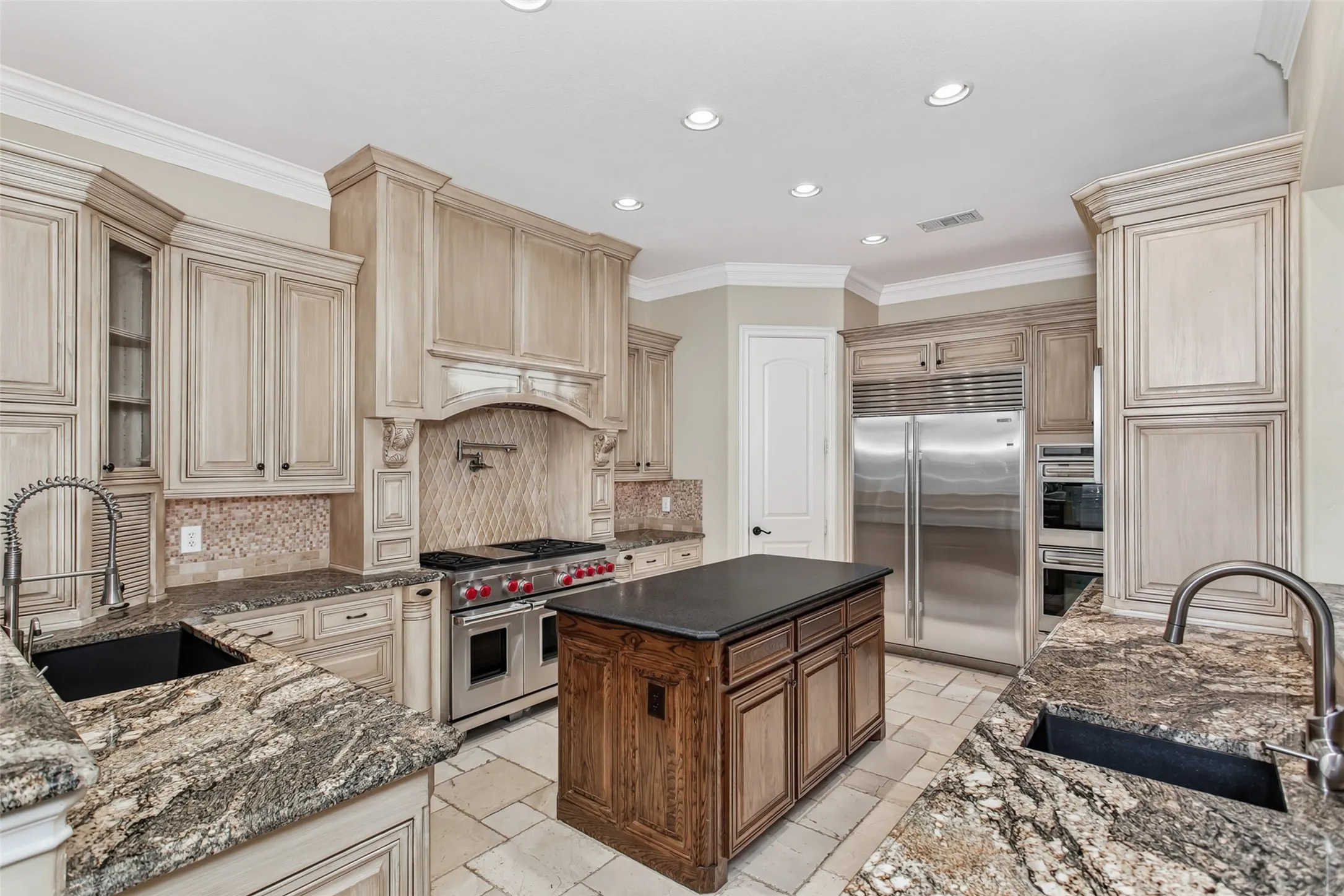 Designed for the serious home chef with a Wolf gas range, double ovens, Sub-Zero refrigerator, oversized island, custom vent hood, and walk-in pantry.