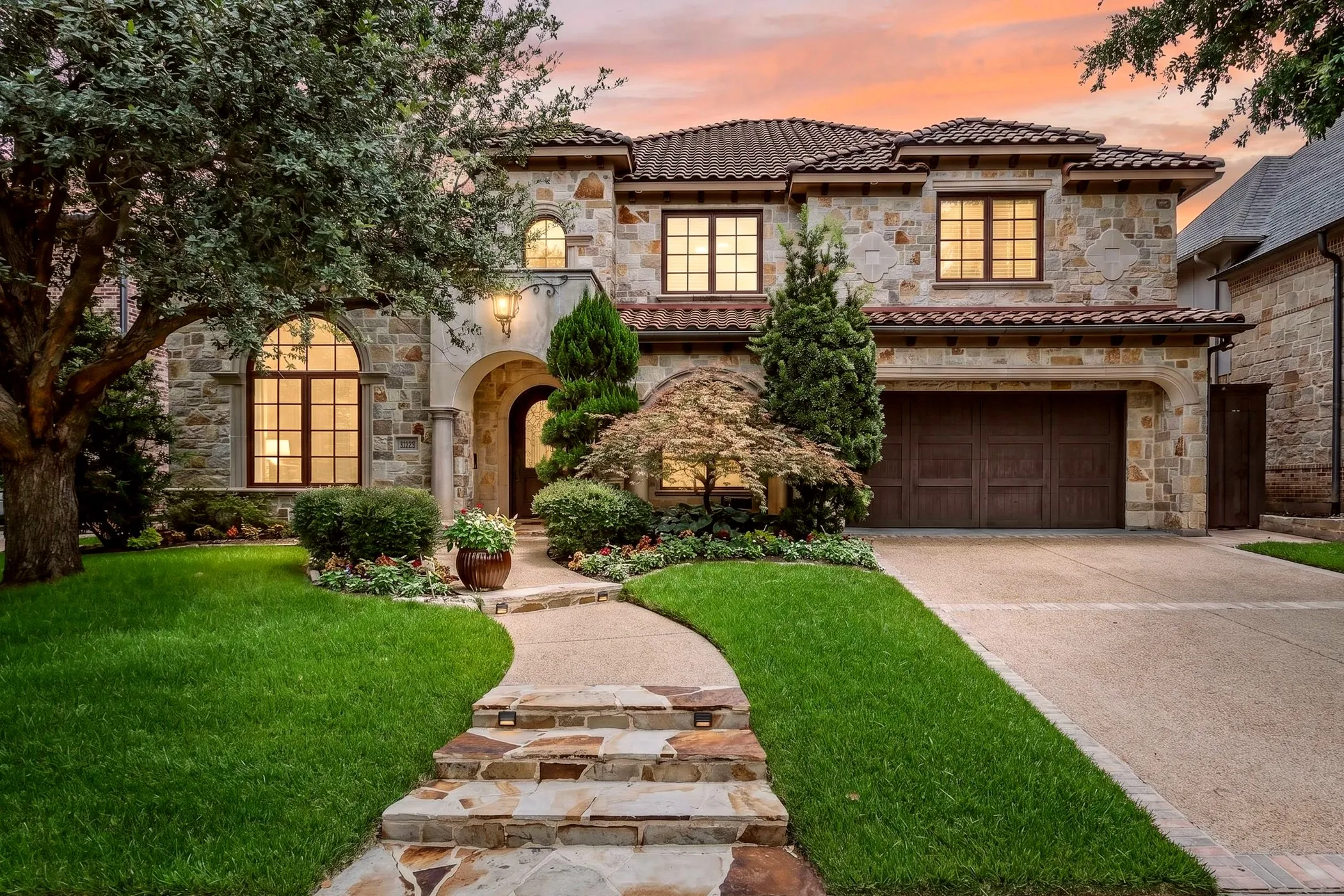 As evening falls, the home's warm lighting highlights the exceptional craftsmanship and timeless elegance of this custom luxury estate.