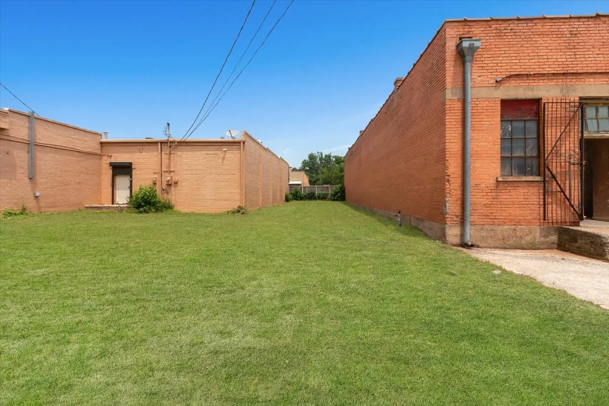 Expansive grassy area situated between two brick structures