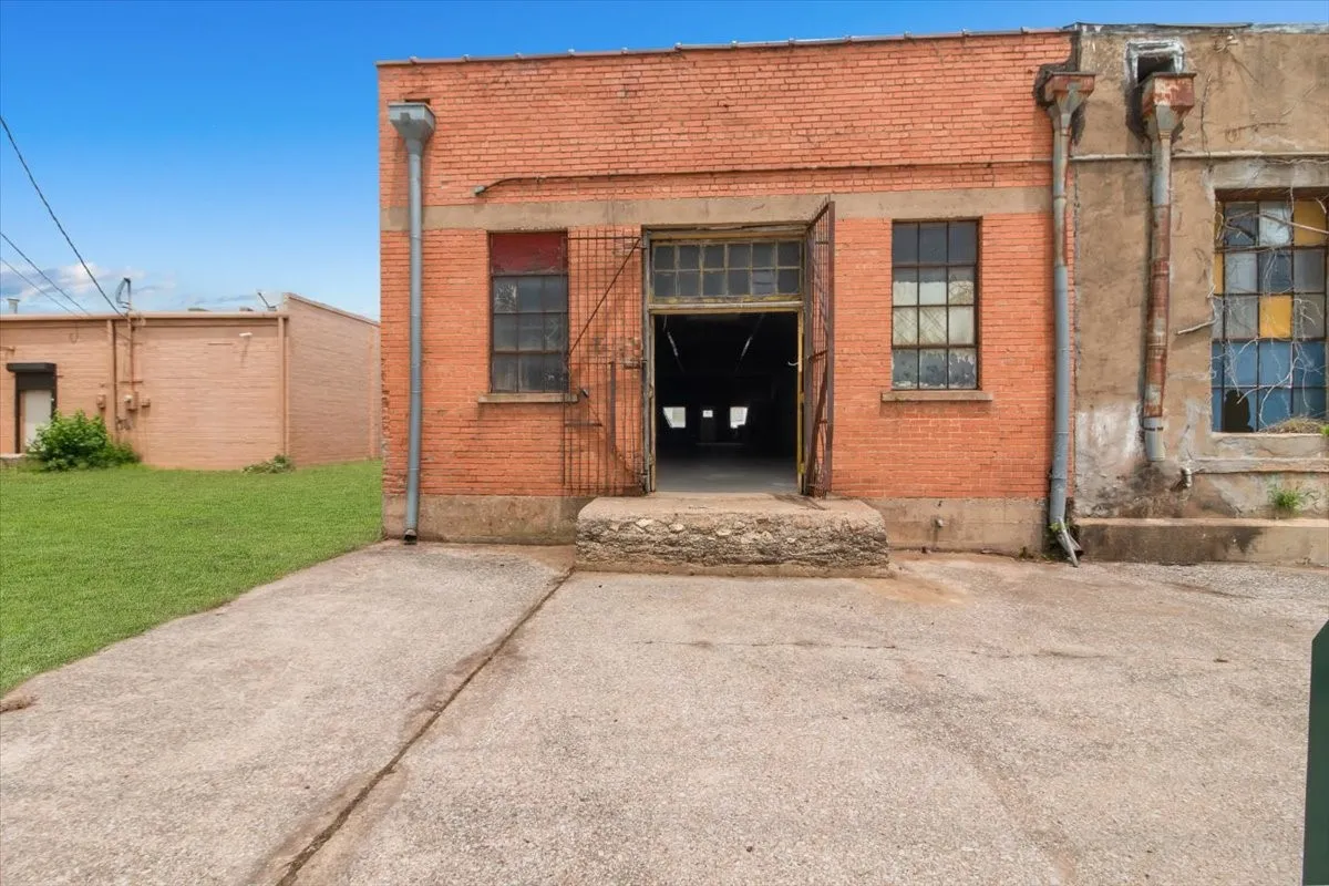 Brick exterior structure with an open entry point and a concrete pad