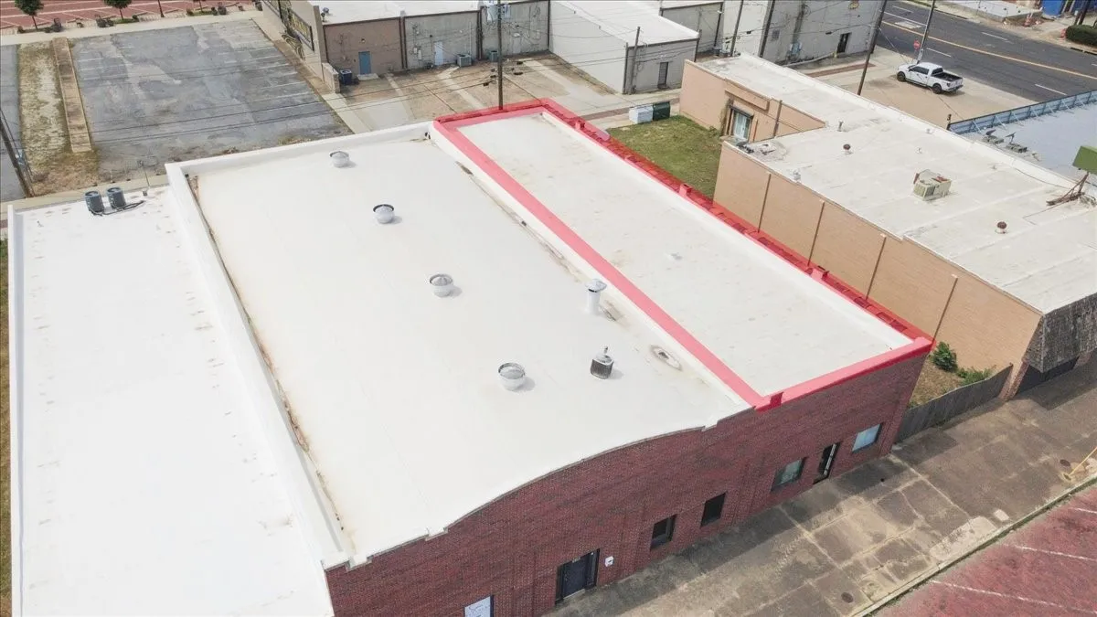 Commercial building with a flat white roof and a red brick facade