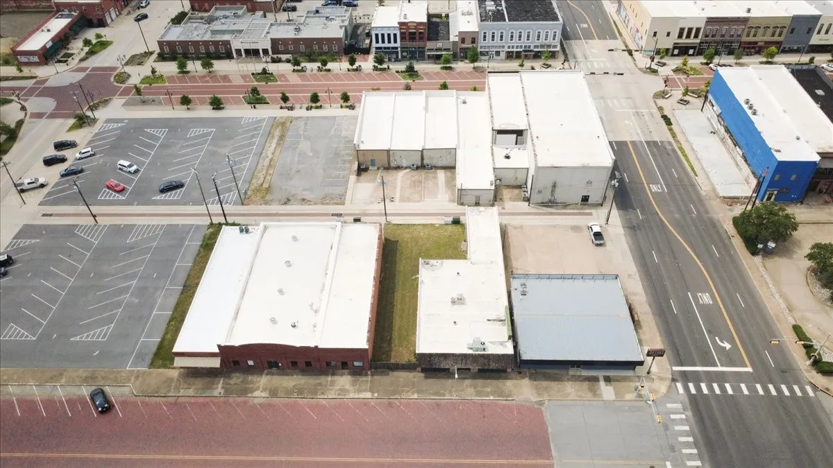 Aerial perspective showcasing multiple commercial buildings situated along a paved street