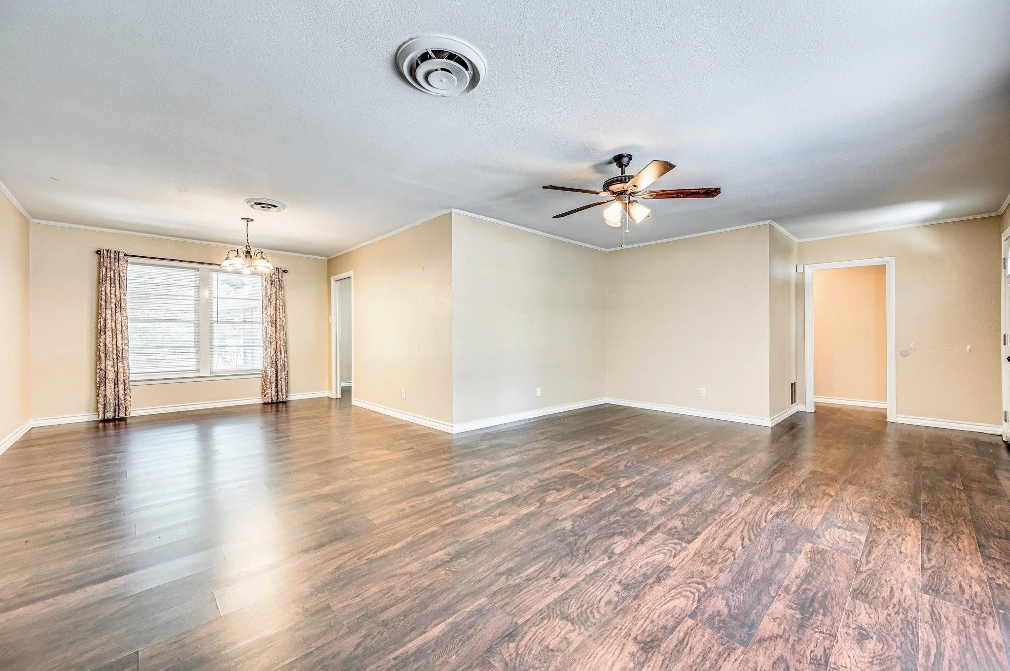 Spacious interior featuring wood-finish flooring, neutral-toned walls, and white baseboards