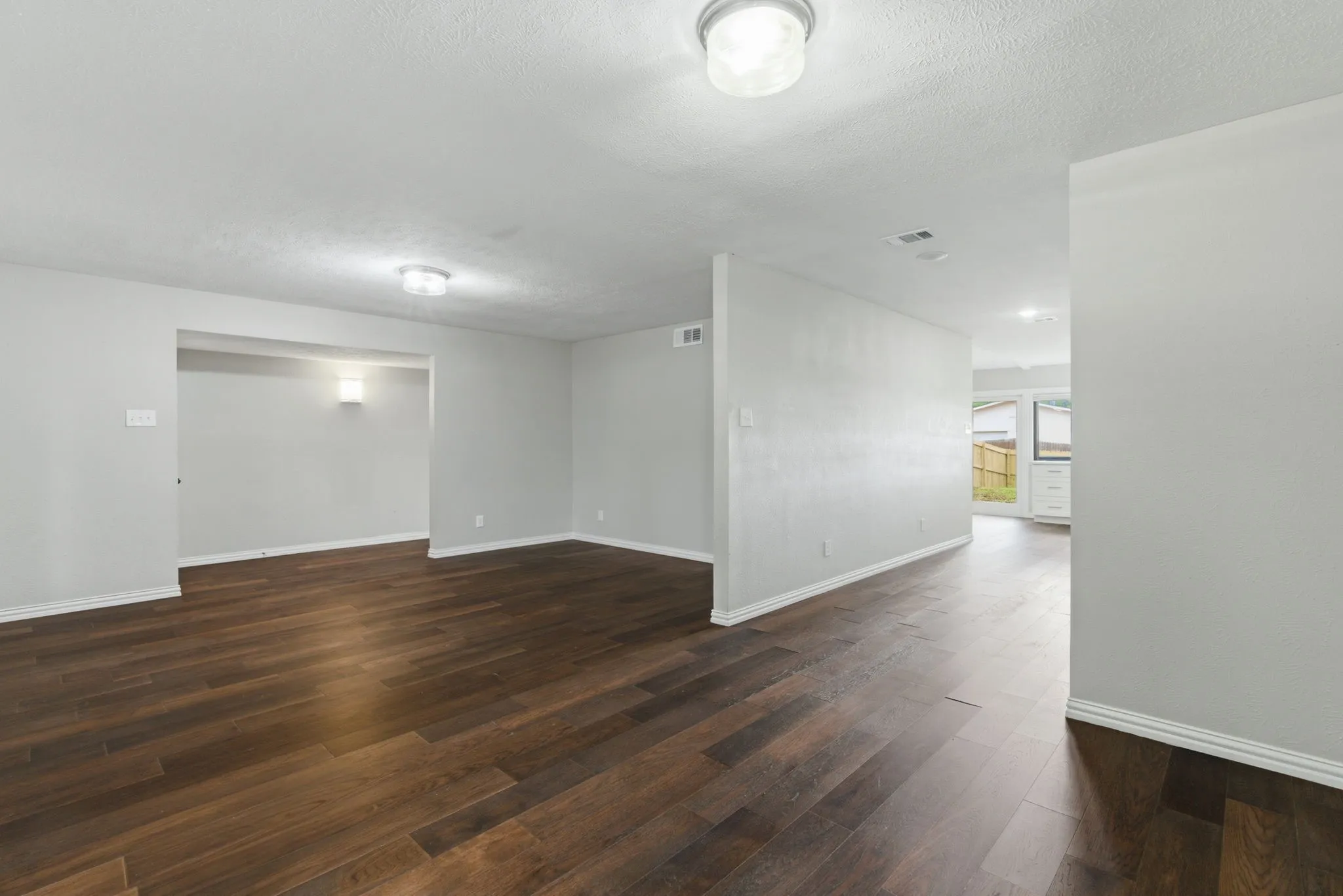 Open-concept living space featuring wood-finish flooring, recessed lighting, and a neutral wall palette