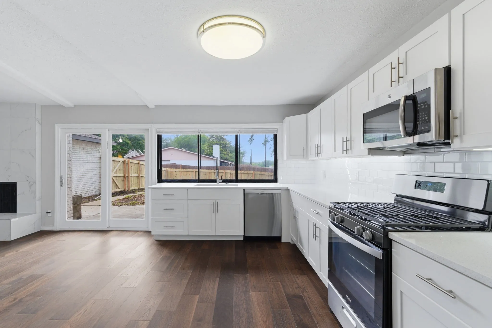 Modern kitchen featuring white shaker cabinetry, stainless steel appliances, and a subway tile backsplash
