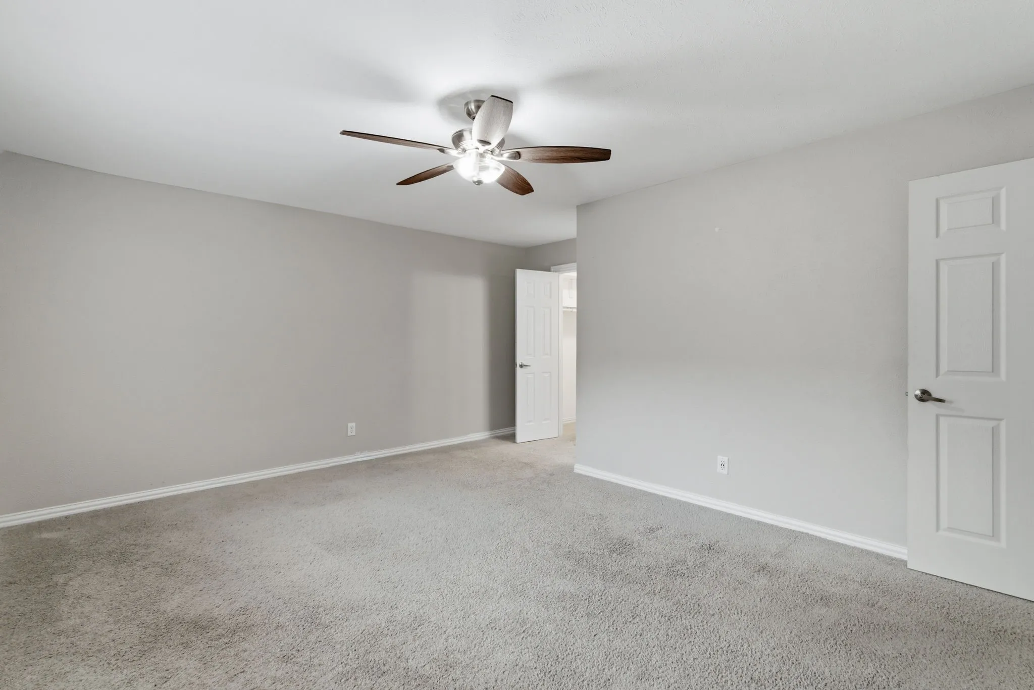Spacious room with light gray wall paint and light-colored carpet