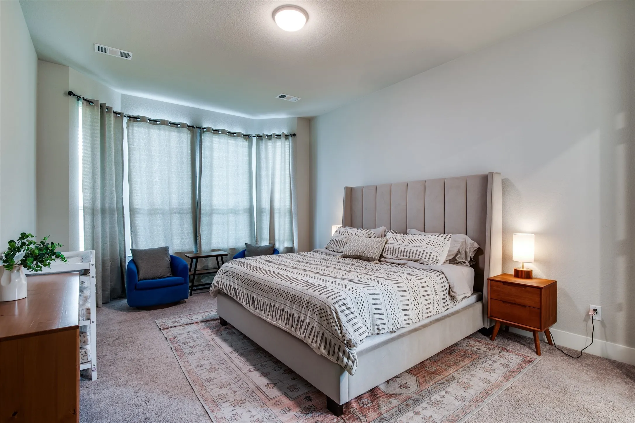 Spacious room with light neutral wall paint and carpeting