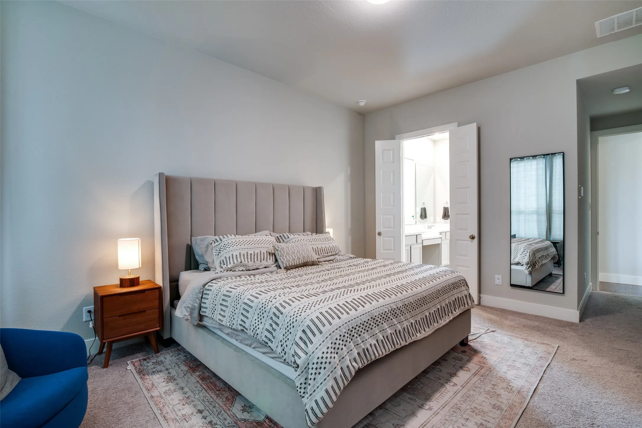 Carpeted sleeping area with light gray walls and a fabric headboard