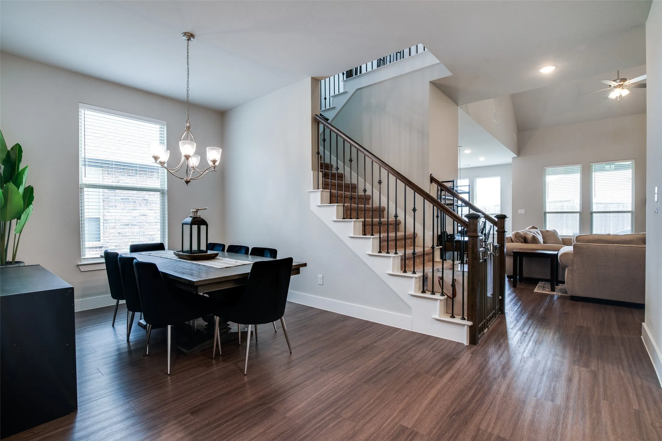 Formal dining area featuring wood-finish flooring, a contemporary chandelier, and ample natural light