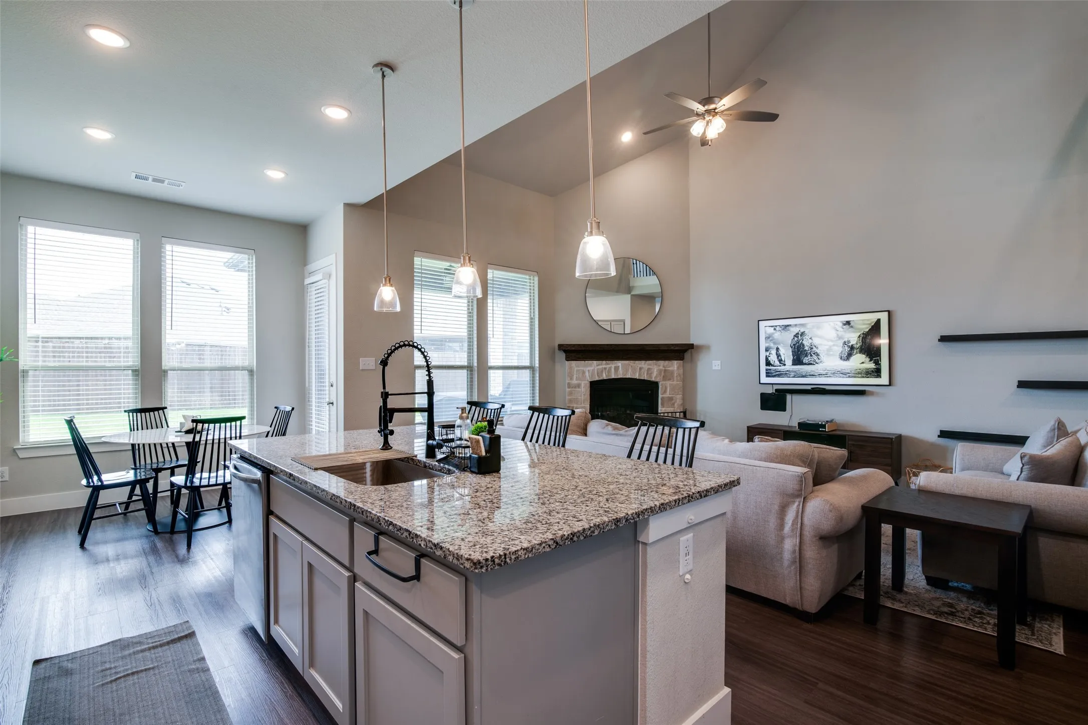 Kitchen island with granite countertop, undermount sink, and matte black faucet