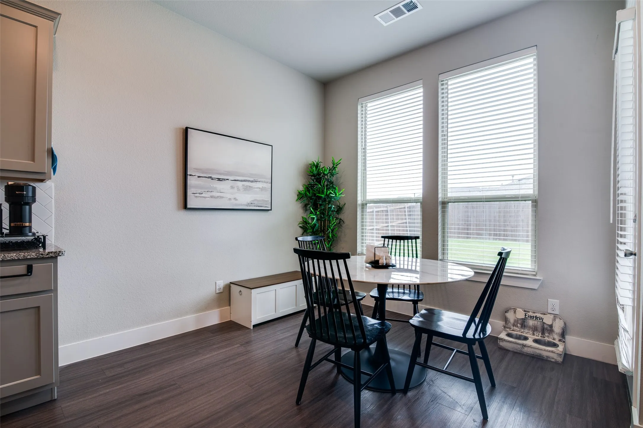 Dining area featuring wood-finish flooring and two large windows with blinds