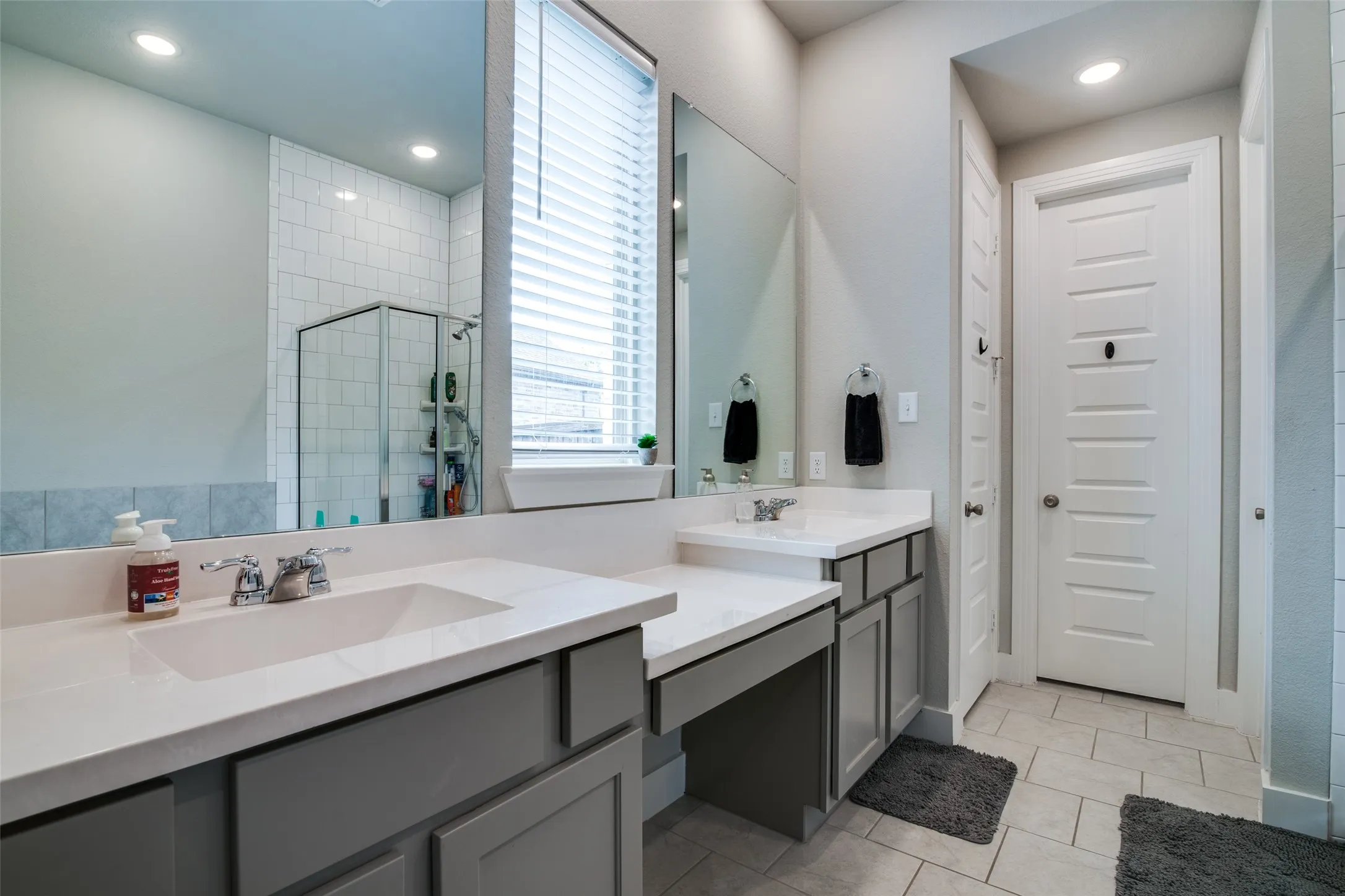 Dual sink vanity with white countertops and grey cabinetry