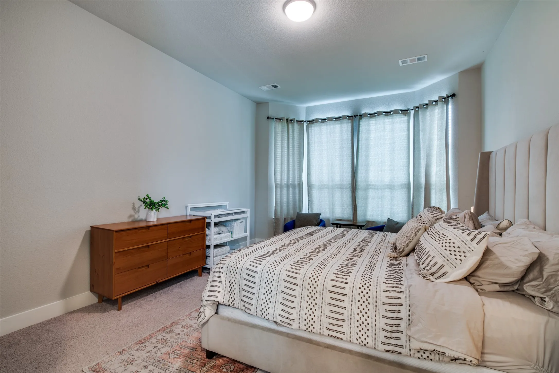 Recessed bay window with multiple large windows, neutral wall color, and carpeted flooring