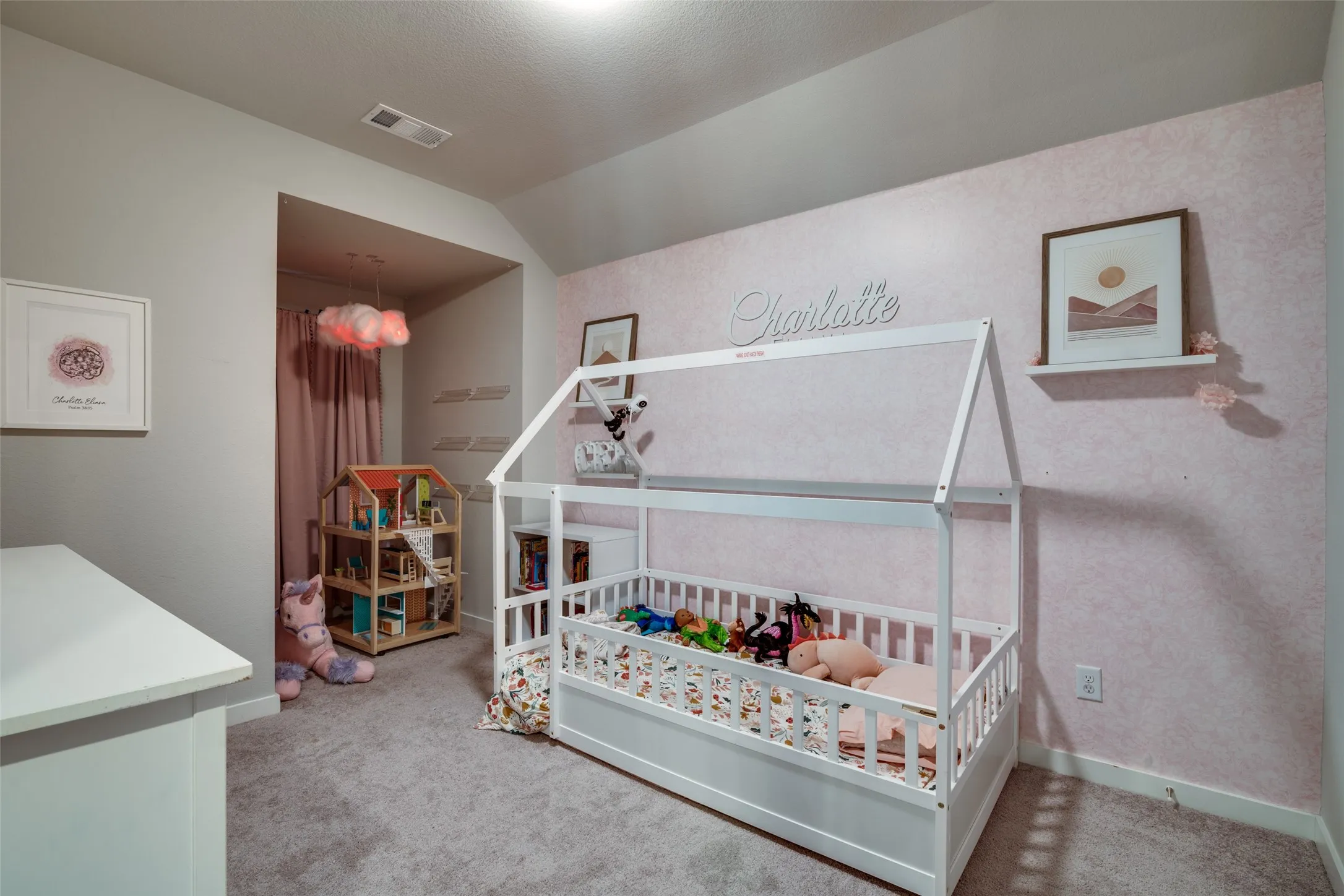 Carpeted room featuring a light pink accent wall, recessed lighting, and a built-in wall niche with a cloud pendant light
