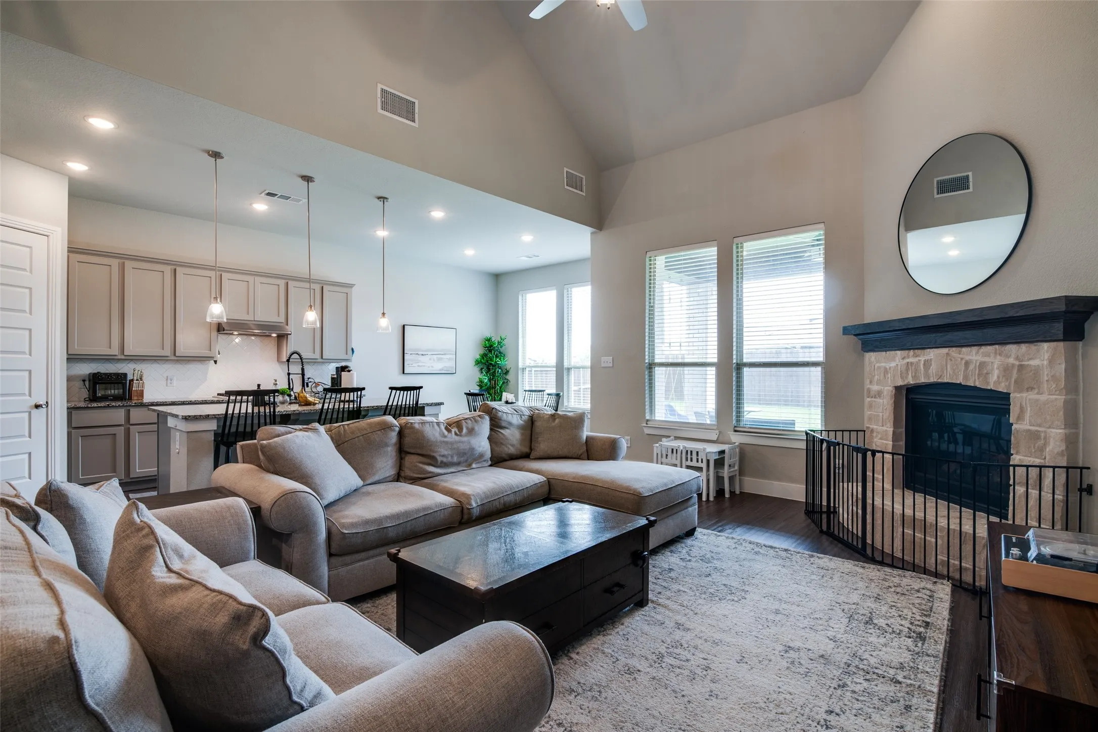 Open-concept living area featuring a vaulted ceiling and dark wood-finish flooring