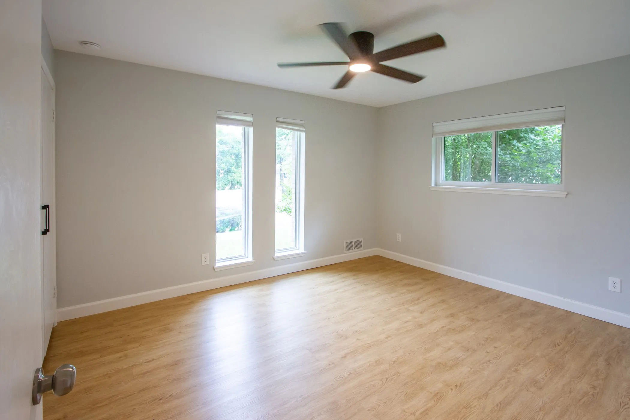 Unfurnished room featuring plenty of natural light, a ceiling fan, wood finished floors, and baseboards